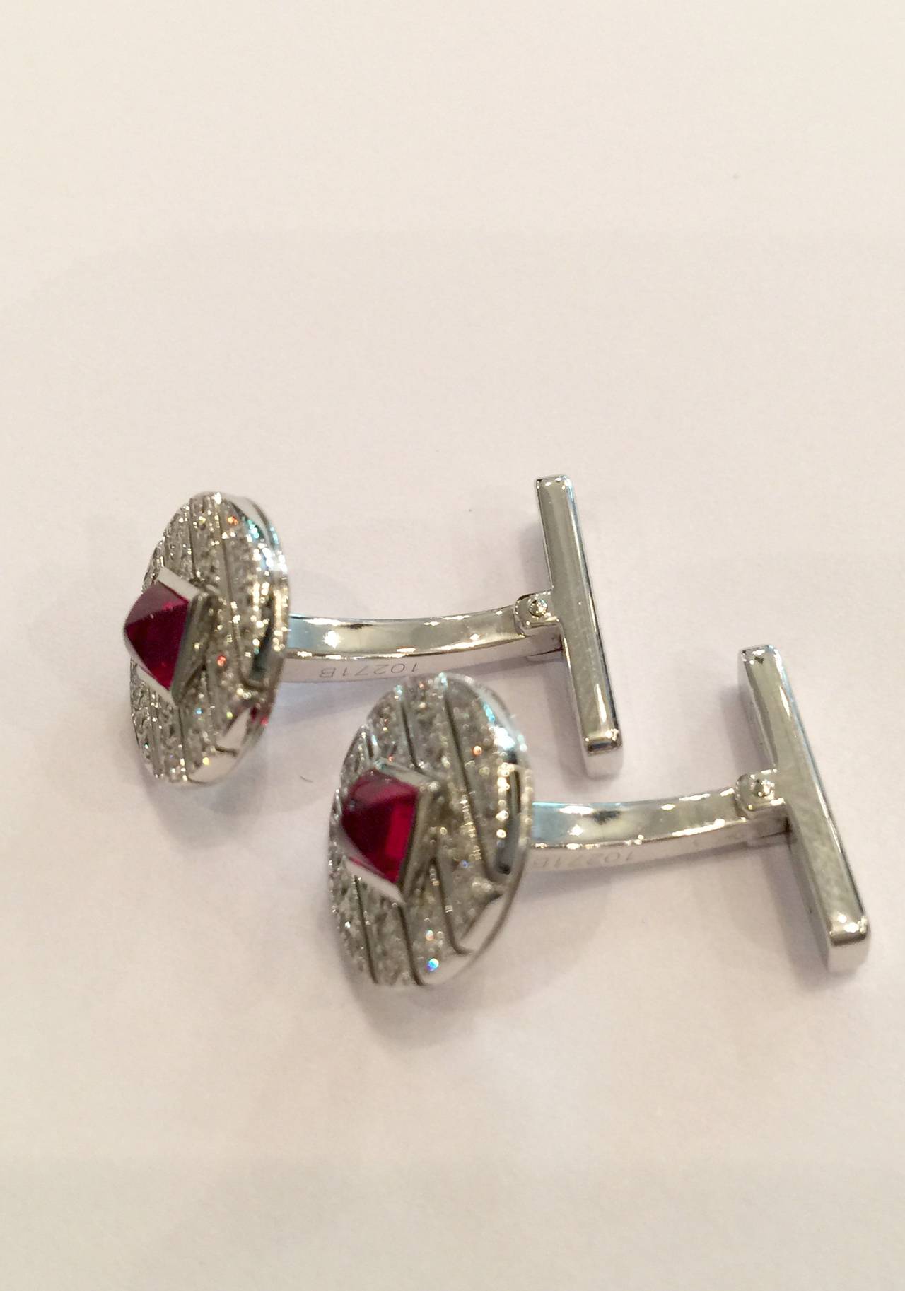 A white gold Cartier pair of cufflinks made with disks set in the middle with exceptional quality cabochon cut rubies and diamonds around the middle stones. 
Diameter : 13 mm
Circa : 2010