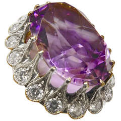Antique Gold and silver ring set with a large oval amethyst surrounding with diamonds.