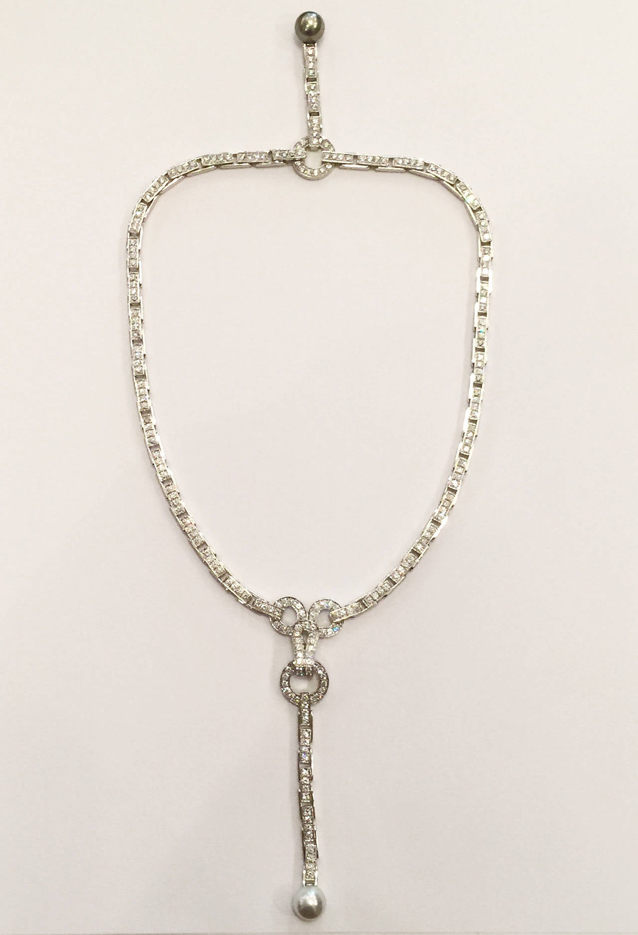 White gold Cartier necklace, Agrafe collection entirely set with brilliants.
The movable face pendant is decorated with a white pearl, the back one with a grey tahitian pearl.
Diamond weight : 18,80 carats
Length of necklace : 40 cm
Retail price