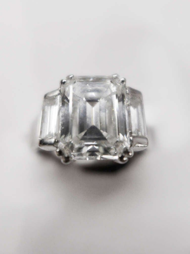 A white gold ring set in the middle with a 3,10 carat emerald cut diamond . 
On each side of the central stone, one baguette cut diamond. 
Baguette cut diamonds weight : 0,75 carat. 
Central diamond quality : F-VS1 
Belgium Gemological