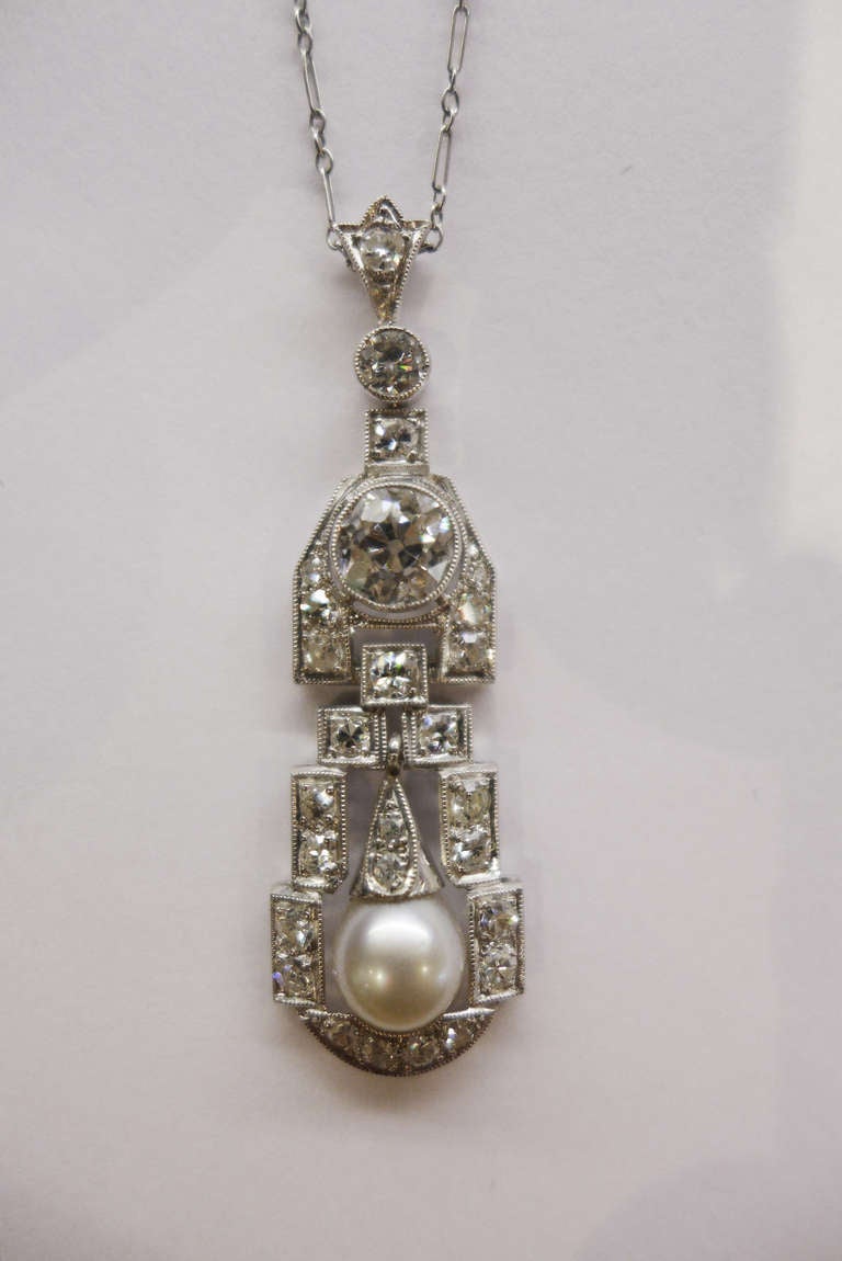 1920's platinum pendant set with old european cut diamonds and a pearl, on a thin platinum chain with a diamond clasp.
Length : 420 mm
Weight of the central stone : about 0,90 carat.