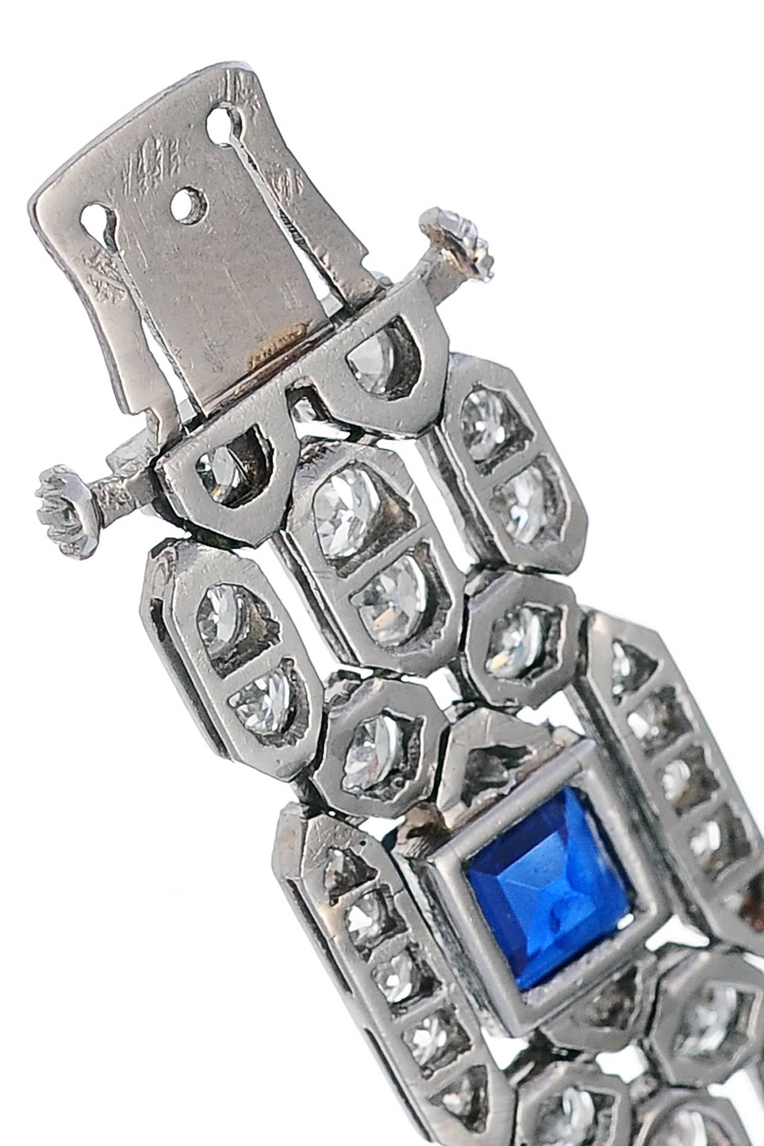Art Deco light platinum bracelet, flat like a ribbon, all set with circular cut diamonds and six square cut Siam sapphires.
French platinum hallmarks and numbered.
High Quality of diamonds : average G-VS
Length : 180 mm  Weight : 26,1