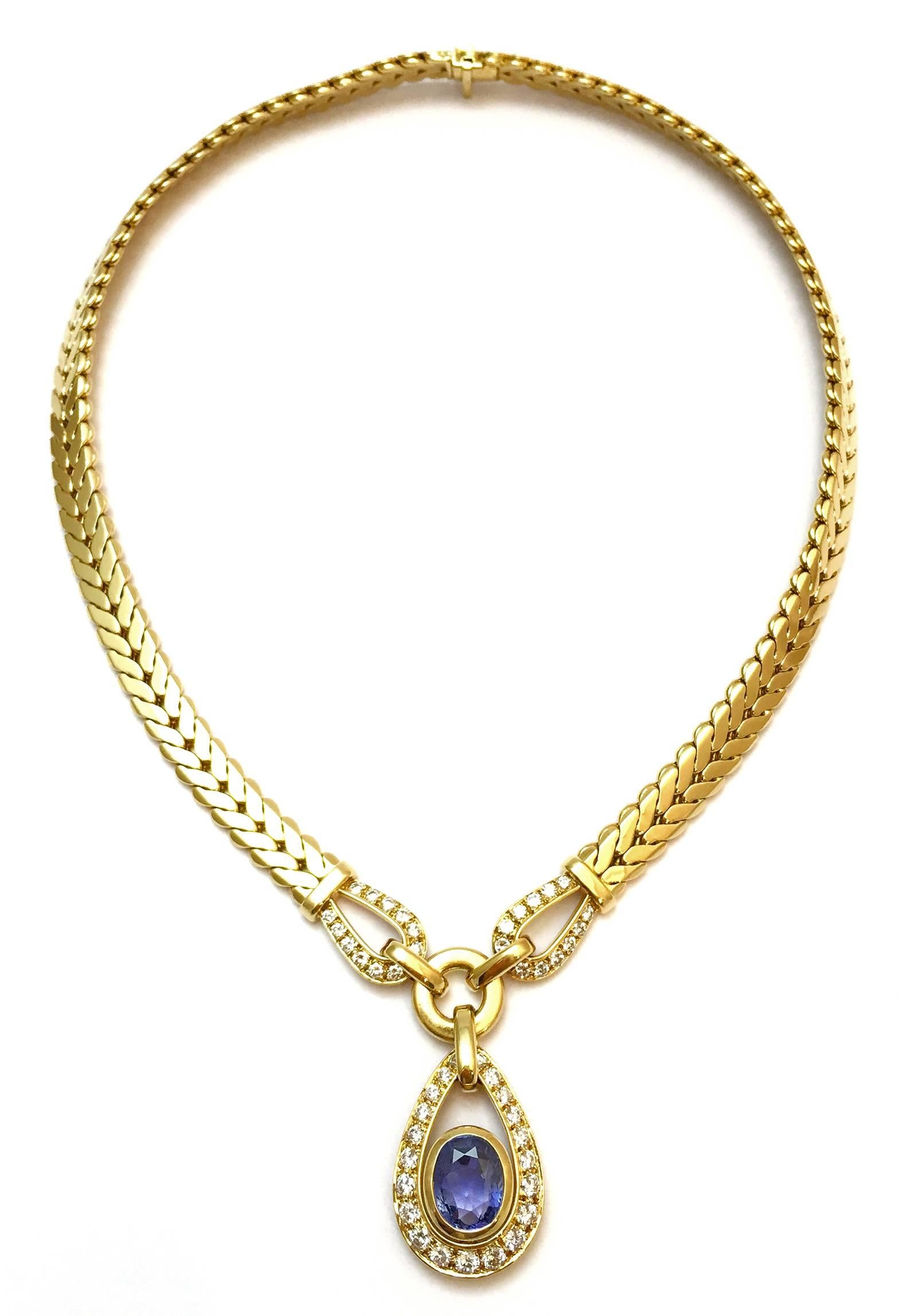 A 750/ooo yellow gold Cartier necklace holding a pendant set with an ovale cut sapphire surrounded with brillant-cut diamonds. 
Total Length of the chain : 400 mm. 
Sapphire length: 10 mm. 
Sapphire width: 8 mm. 
Net weight: 78,5 grams.
Signed and