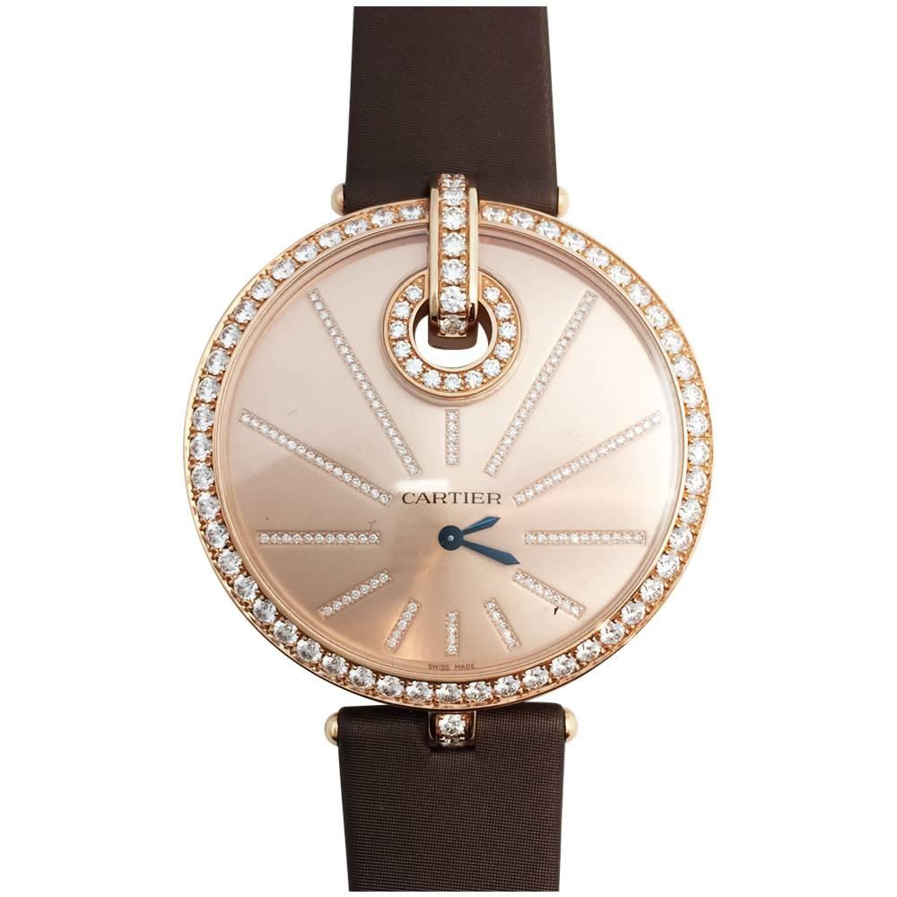 A 750/000 pink Gold Cartier Jewelry watch, Captive XL collection, figuring a sundial. The bezel, the hour markers, and the pin buckle are set with diamonds, technical leather bracelet, pink dial. 
Quartz movement.
Year 2010. 
Retail price: 50 500