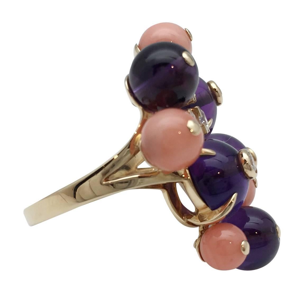 A Cartier ring, Délices de Goa collection in 750/000 gold set with polished angel skin colour coral and amethyst beads accented with brilliant-cut diamonds. 
Finger size: 6, can be sized. 
We also sell a necklace of the same collection.
Width 25 mm.