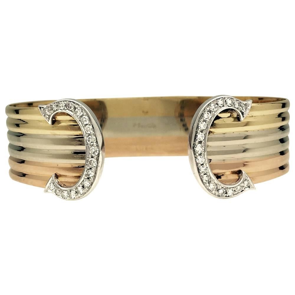 A 750/000 three colour of golds gadrooned Cartier bracelet, "C de Cartier" collection, with two C patterns set with brillant cut diamonds.
Width : 15 mm
Diameter : 62 mm inside diameter
Style Period 1980
