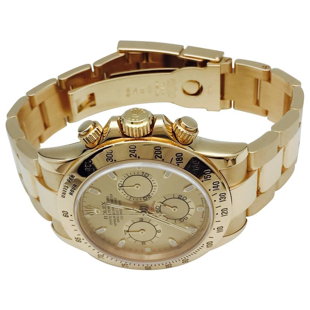 A 750/000 yellow gold chronographe Rolex watch, "Cosmograph Daytona" collection. Champagne color dial, oyster bracelet, folding clasp, fixed bezel, with engraved tachymetric scale.
Self-winding movement 
Circa 2003
Retail price: 31 800
