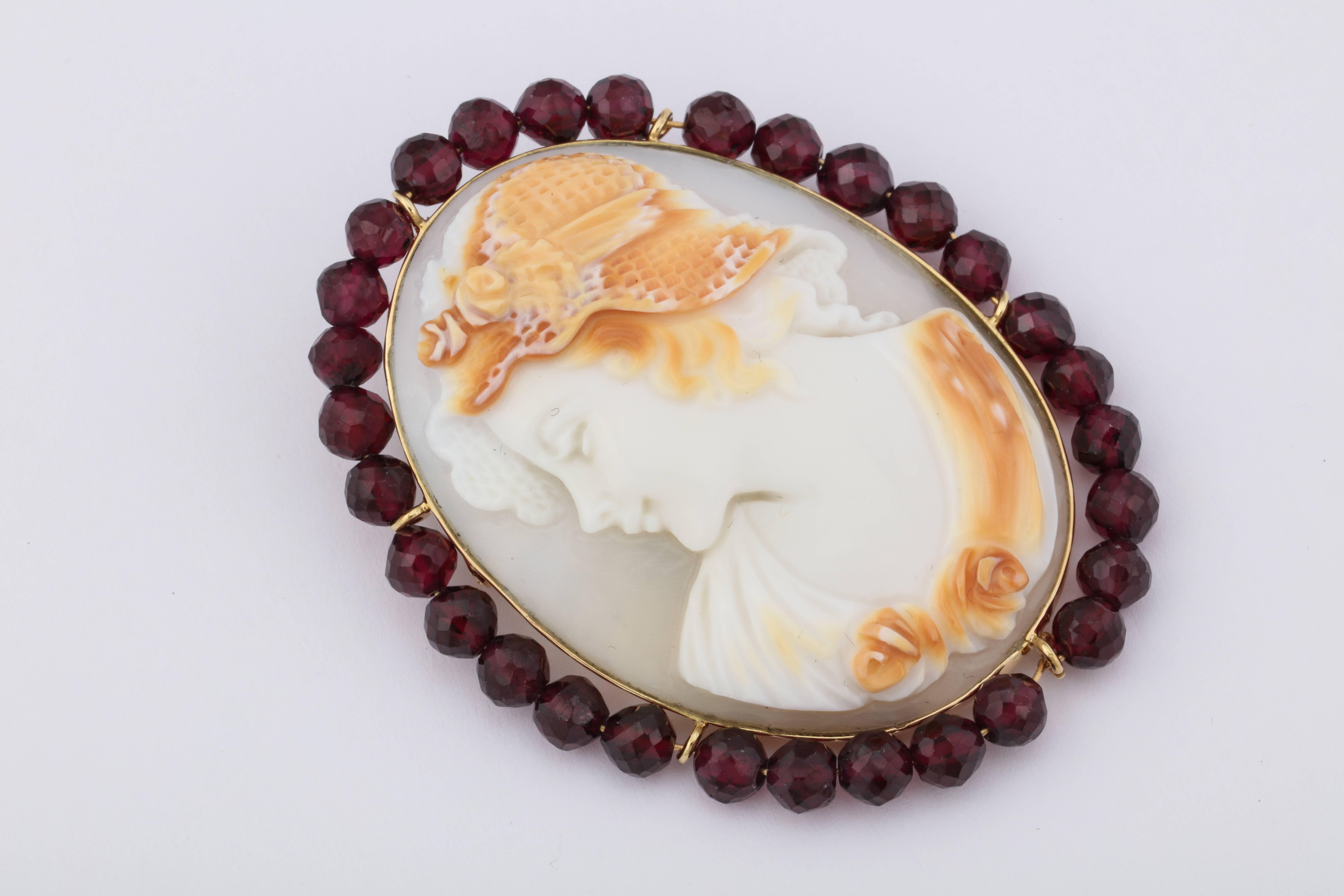 Hand carved cornelian cameo set in 14kt gold pin/pendant surrounded by garnet beads.