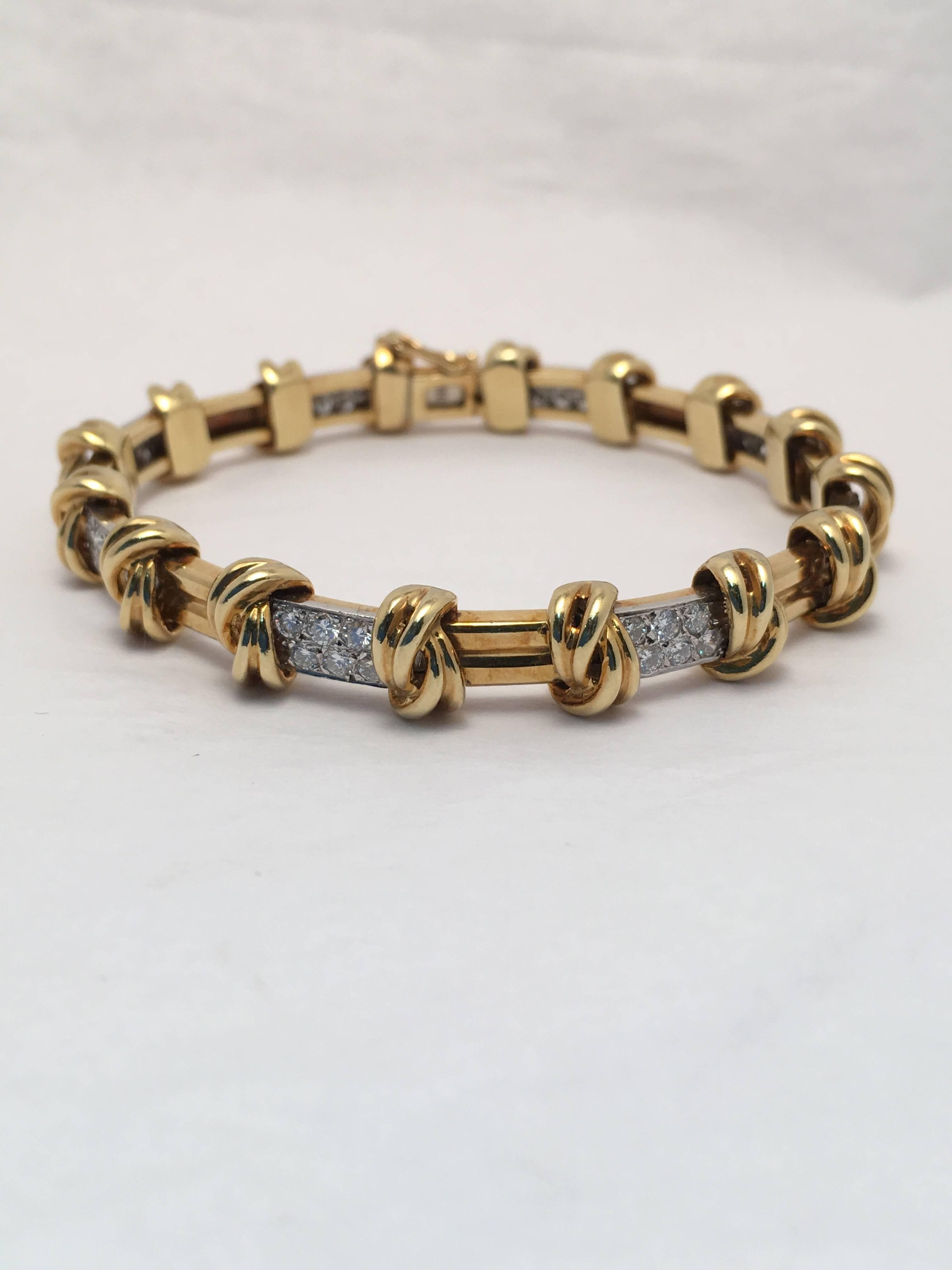 Bracelet consists of fifteen sections sections of which eight sections are set with six round brilliant diamonds; SI1/F-G and seven sections of two high polished horizontal bars.  Each section is separated by a yellow gold knot. 