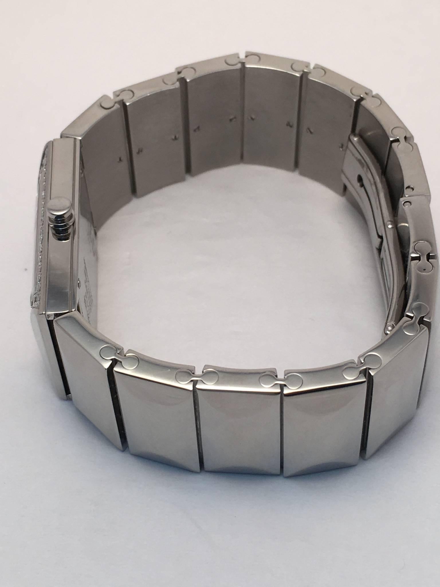 Ladies stainless steel Fred watch set with 52 round brilliant diamonds around white dial weighing approximately .50 ct. total weight. Case measures 30 x 20 mm. and bracelet is 20 mm. wide and closes via deployant buckle. Watch has a Quartz movement