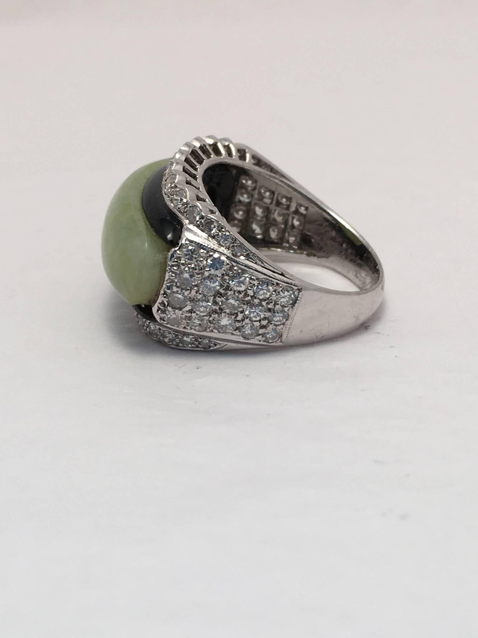 Platinum ring is set with onyx and jadeite jade surrounded by 64 round brilliant diamonds weighing approximately 1.28 ct. total weight.  