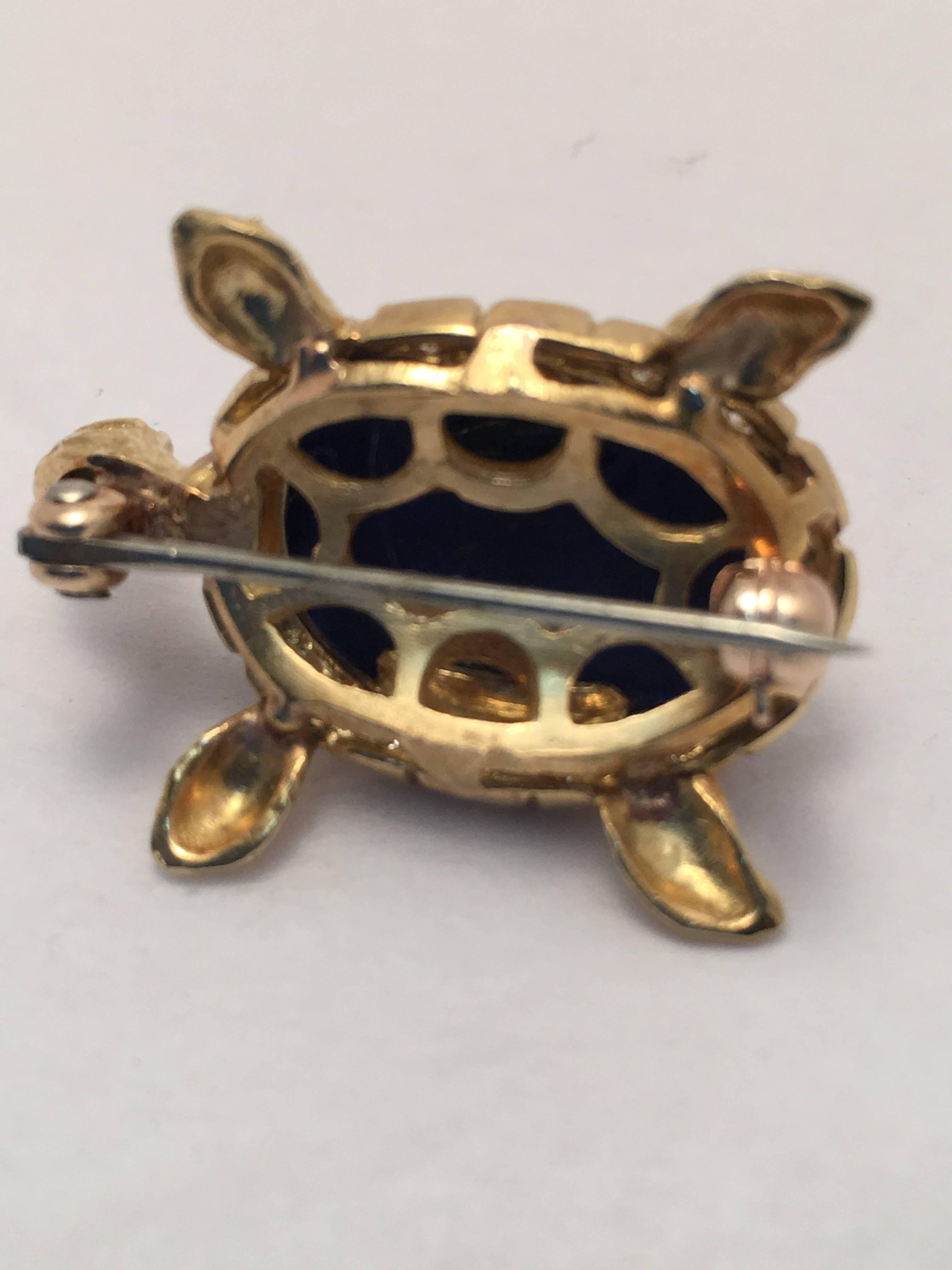 This wonderful turtle is set with a beautiful oval lapis lazuli cabochon stone and surrounded by 16 round diamonds weighing approximately .35 ct. total weight.  The eyes of the turtle are 2 round emeralds.  