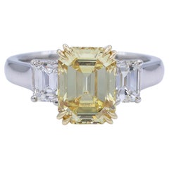 Bague à trois pierres, taille émeraude, de couleur jaune vif « Fancy Vivid » certifiée GIA, d'un poids total de 3,40 carats