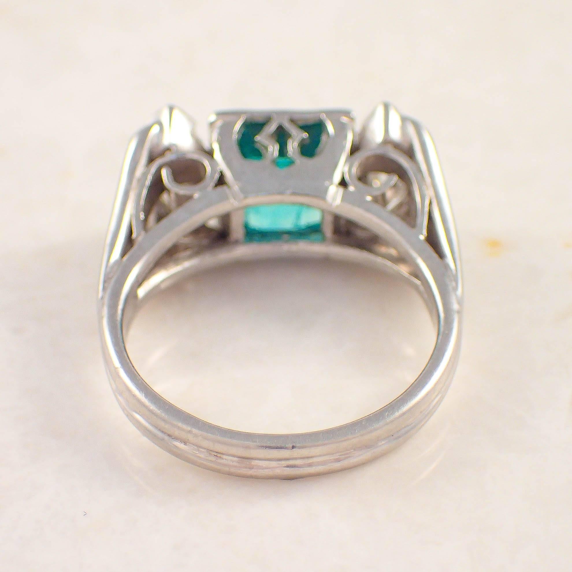 Platinum emerald and diamond ring. The open work setting is centered with one approximately 1.62 carat square cut emerald measuring 6.9 X 6.7 X 5.4 mm, flanked by two long hexagon cut diamonds weighing approximately .70 carat total.

Color: