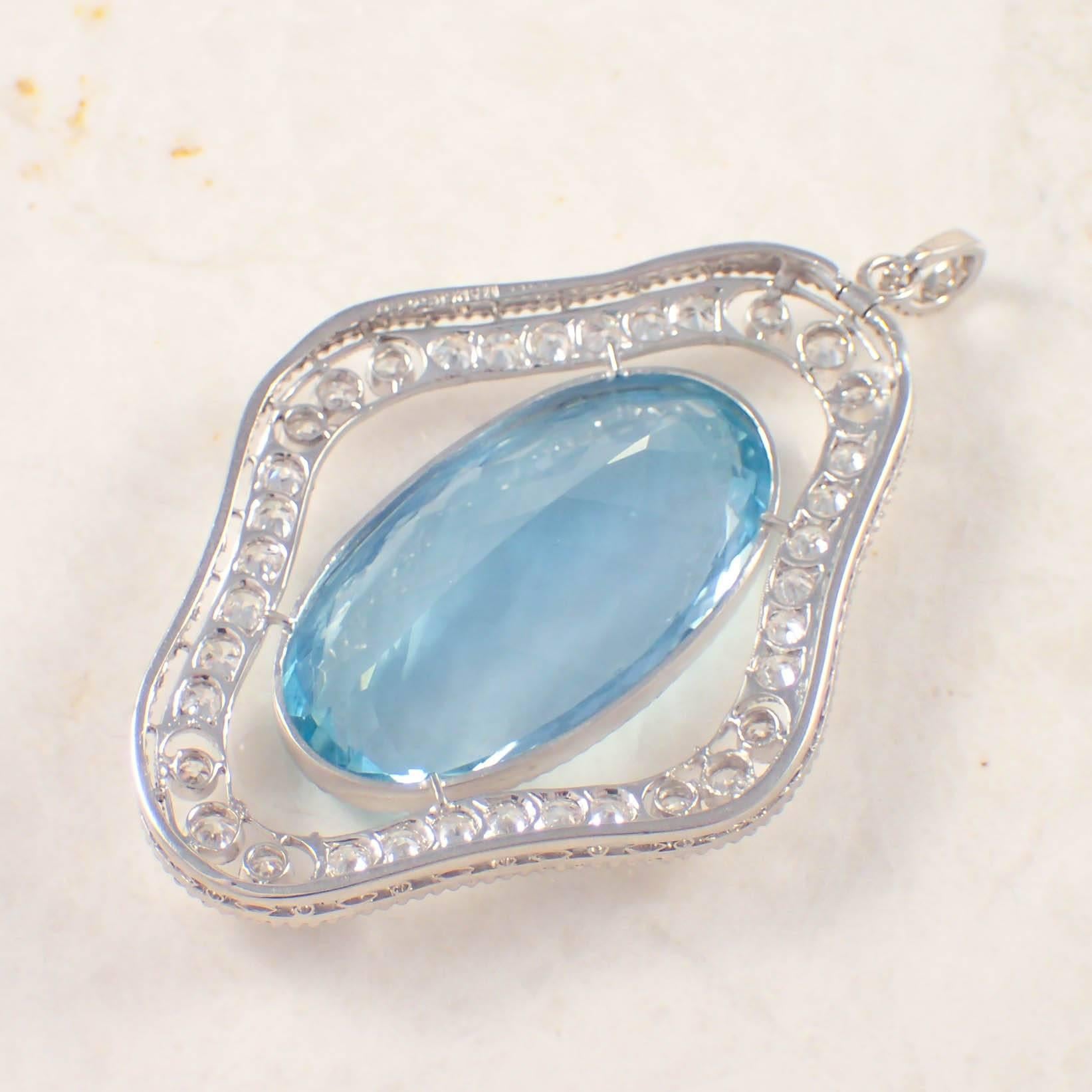 Platinum Art Deco aquamarine and diamond Marcus & Co. pendant. The shield shaped, open work pendant is set with one oval aquamarine measuring 26 X 14 mm surrounded by 30 European cut diamonds weighing approximately 1.50 carats total. The pendant