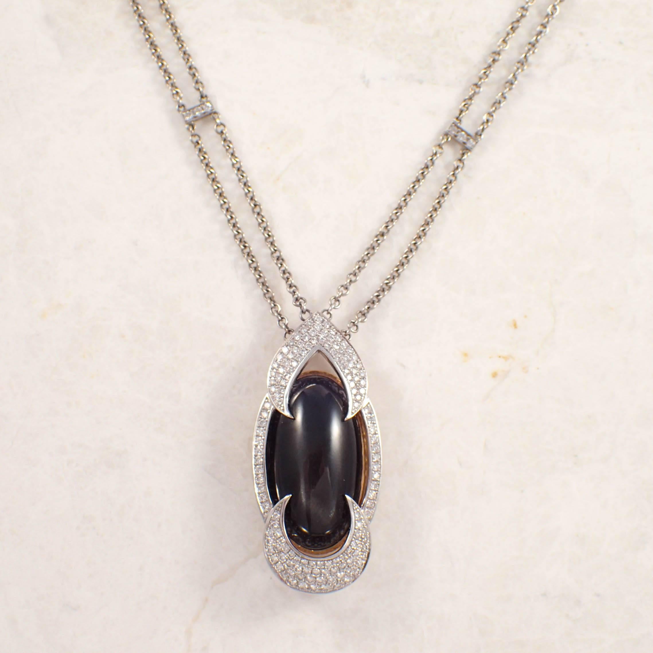 18k white gold black star sapphire and diamond necklace.  The custom necklace set with one black star sapphire weighing approximately 20.00 carats, and pave set with small round diamonds weighing approximately 1.50 carats total.
Circa