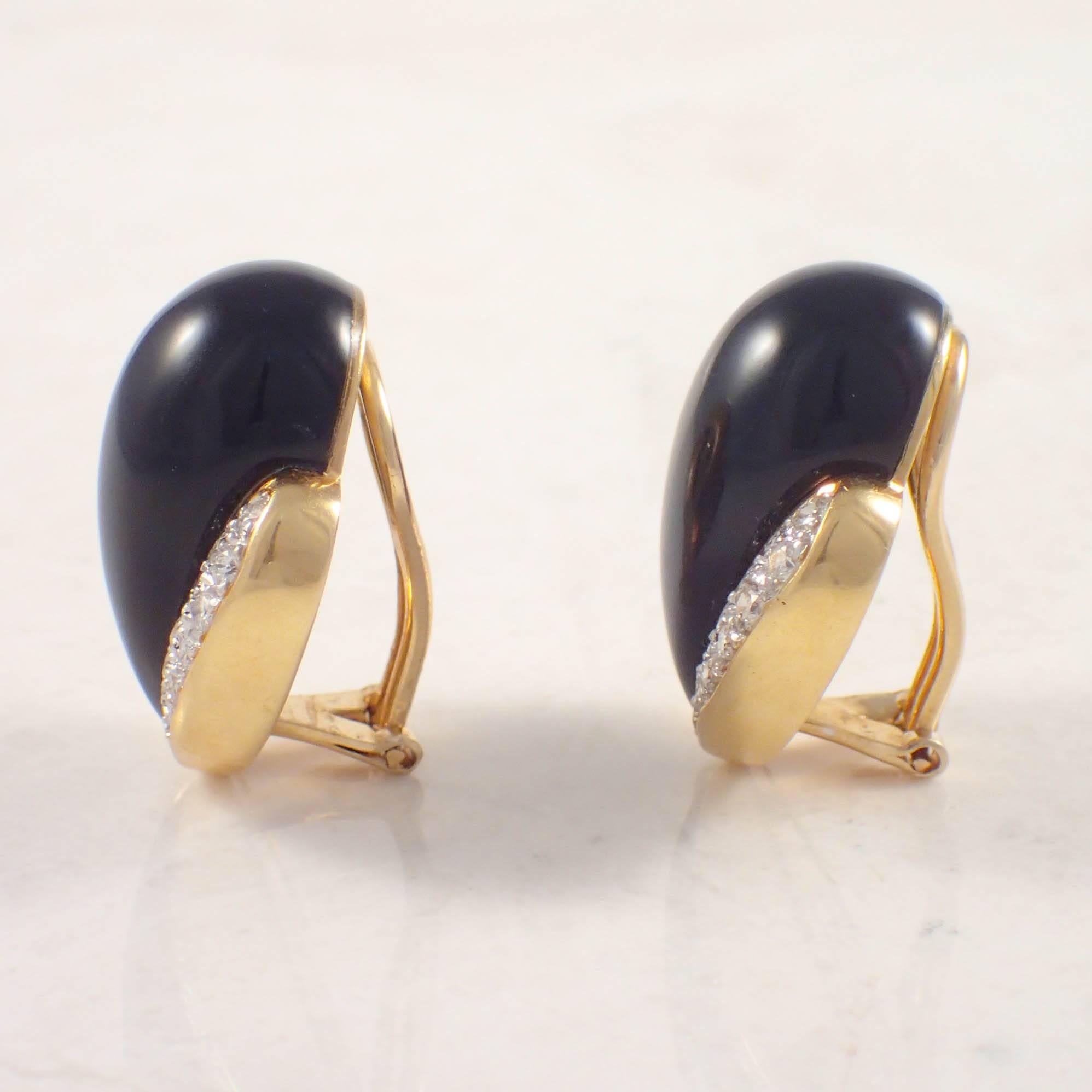 18K Yellow gold onyx and diamond clip earrings. The earrings are set with cabochon cut, pear shaped onyx pieces measuring 24 X 13 mm, accented by 44 round diamonds weighing approximately 1.50 carats total. The earrings weigh 20.2 grams. Circa