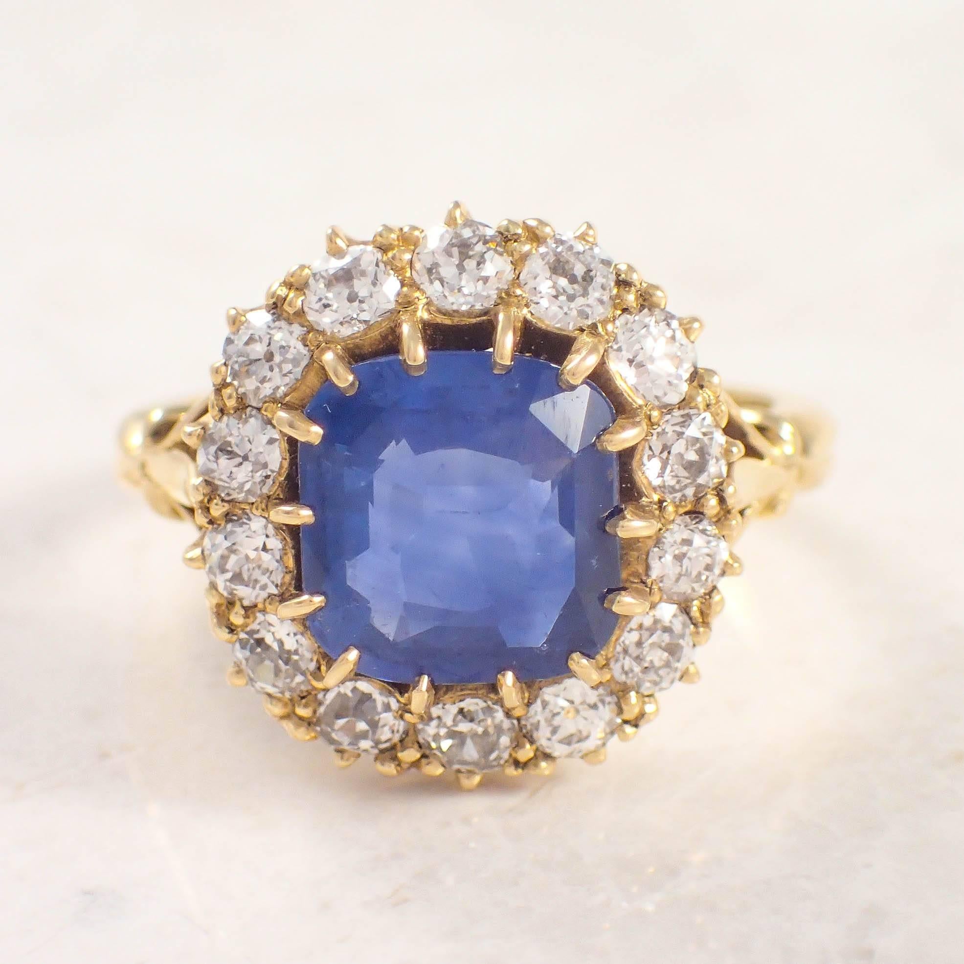 18K Yellow gold sapphire and diamond ring. The cluster style ring is centered with a 3.21 carat cushion cut sapphire, accented by 14 diamonds weighing approximately 1.14 carats total. Circa 1890s.

Color: H-I
Clarity: SI