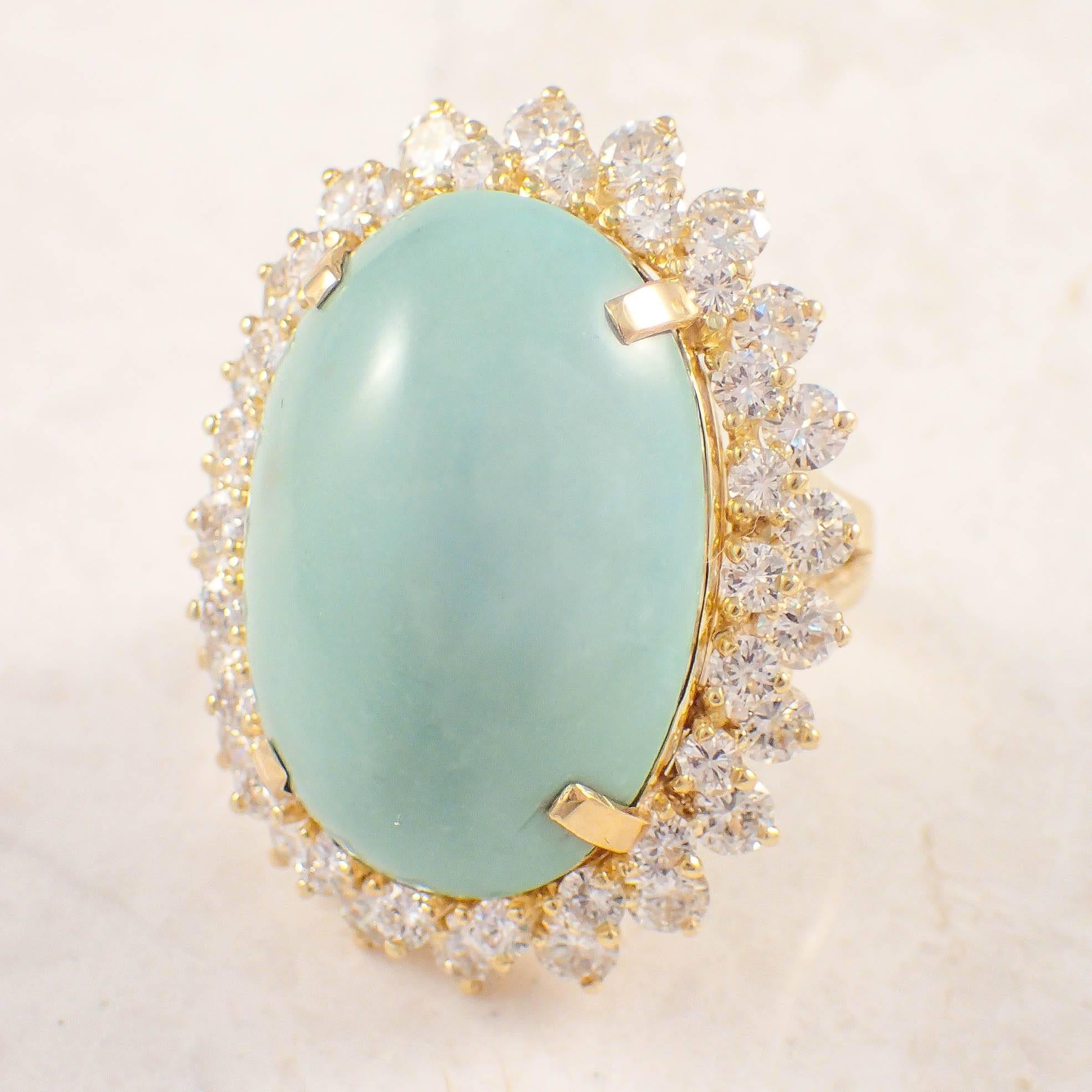 18K Yellow gold turquoise and diamond ring. The cluster style ring is set with one large oval turquoise measuring 25 X 17.9 mm surrounded by 45 round diamonds weighing approximately 3.50 carats total. The ring weighs 21.1 grams. Size 6.5. Circa