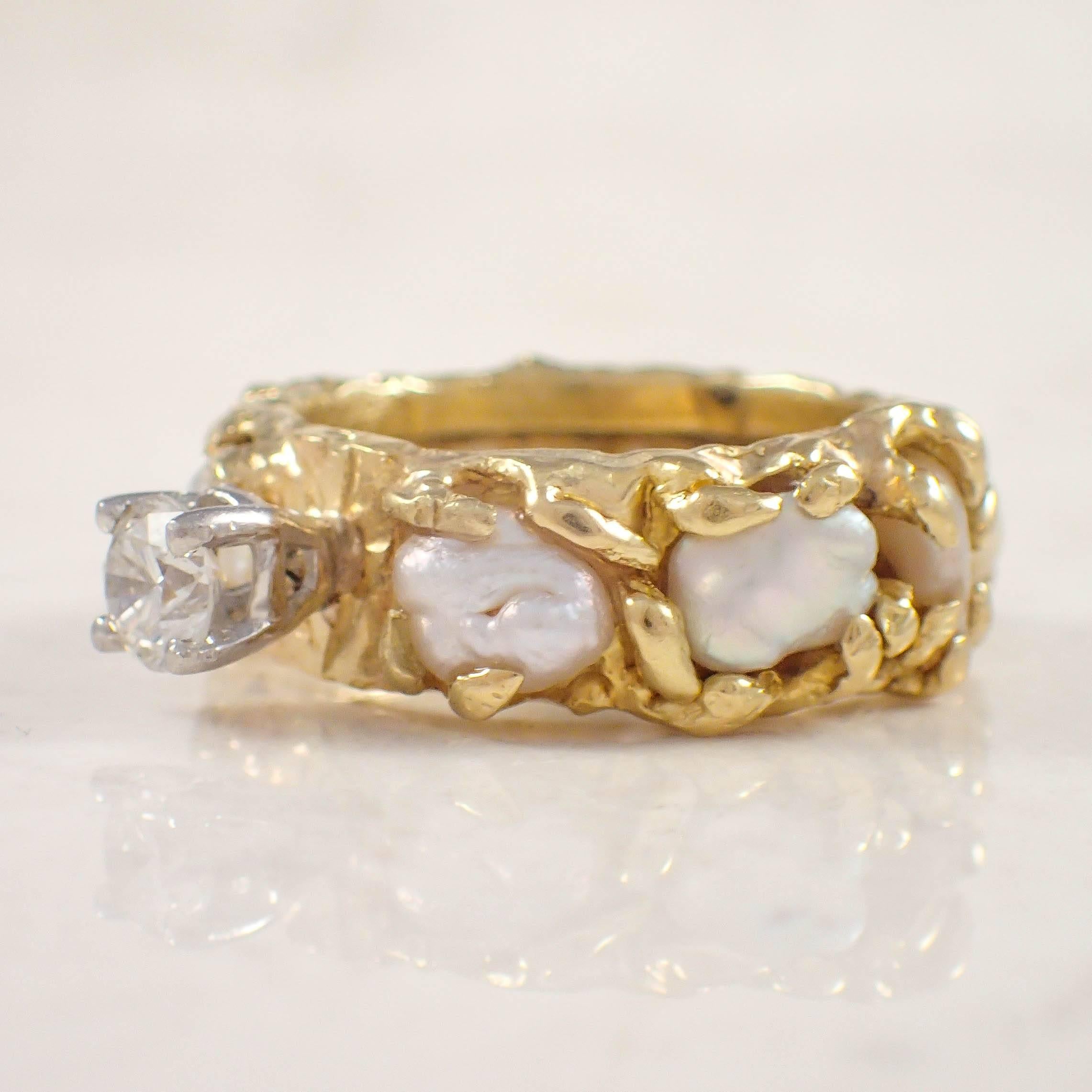 18K Yellow gold diamond and pearl Barbara Anton engagement ring. The four prong head is set with an approximately .50 carat round diamond. The wide band measures 8.9 mm, and is decorated with 9 cultured pearls. The ring weighs 10.5 grams. Stamped 