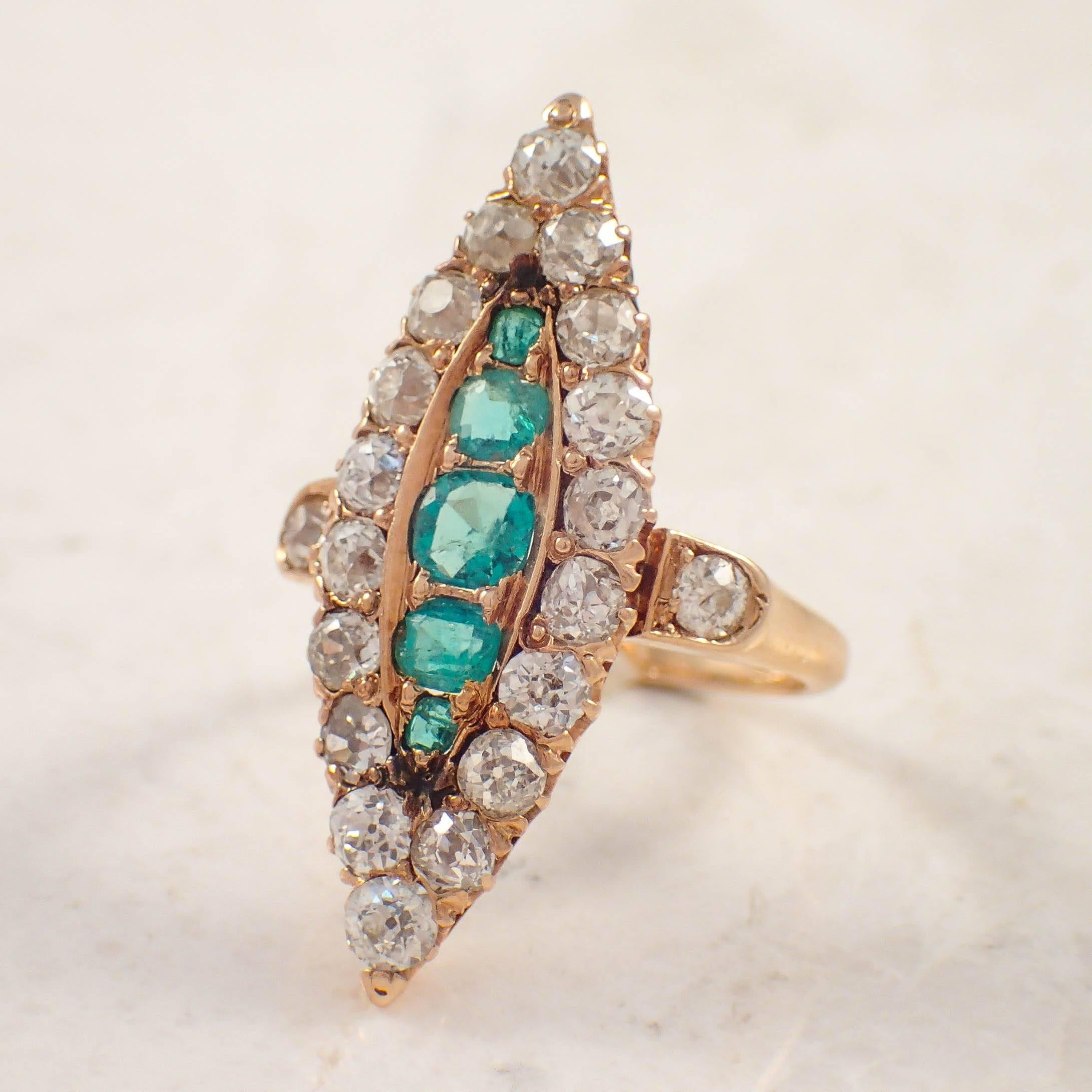 Victorian 14k yellow gold emerald and diamond ring. The navette cluster ring is centered with 5 graduated old cushion cut emeralds weighing approximately .50 carat total, accented by 20 old mine cut diamonds weighing approximately 1.60 carats total.