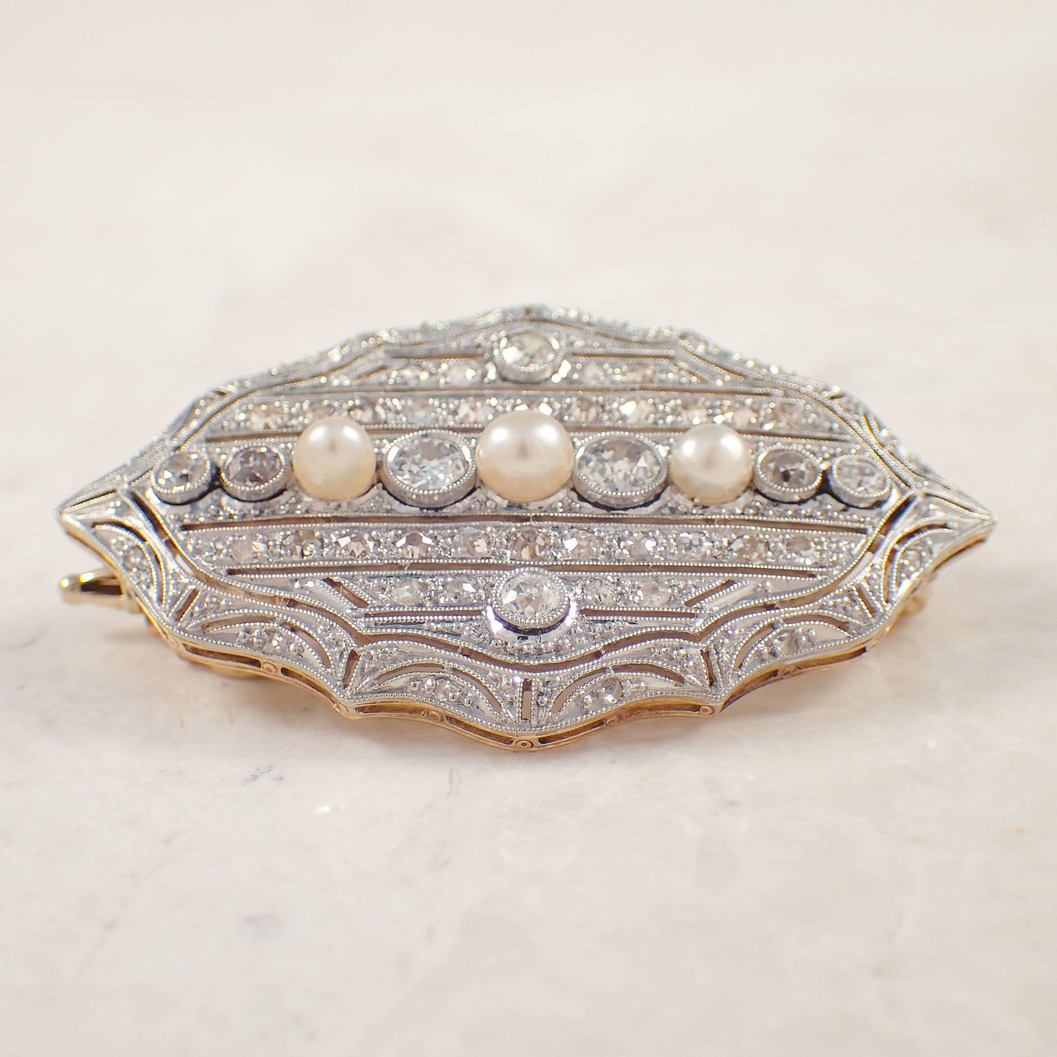 Edwardian platinum over gold pearl and diamond pin/ pendant. The shield shaped, open work pin/ pendant is set with 3 pearls, and 50 old mine and rose cut diamonds weighing approximately 1.50 carats total.  The pendant measures 1.75 X 1 inch, and