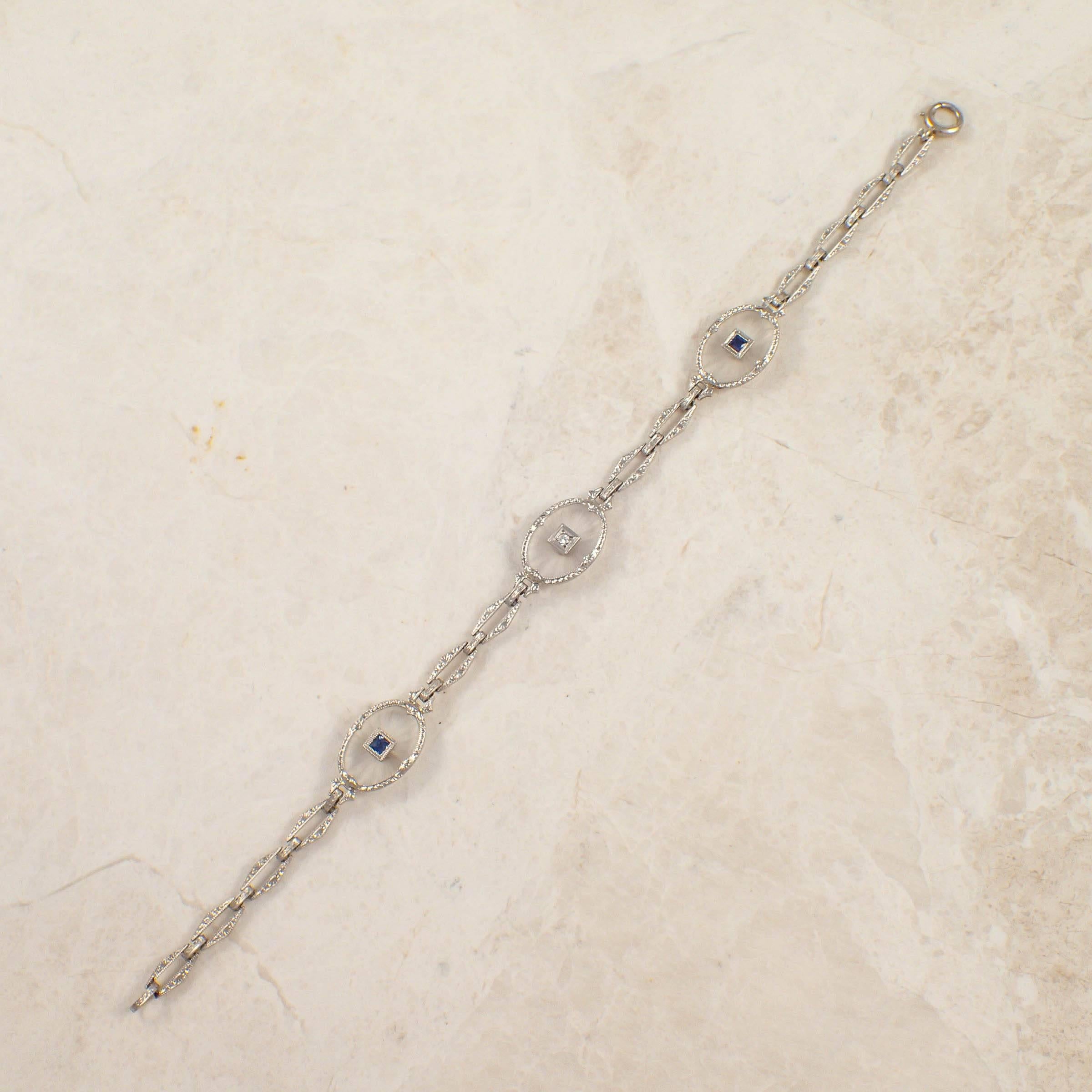 Art Deco 14k white gold crystal, sapphire and diamond bracelet. The 3 oval, 14 X 10 mm carved crystal links are set with 2 square cut small sapphires and one small round diamond weighing approximately .03 carat total. The bracelet measures 14 mm X 7