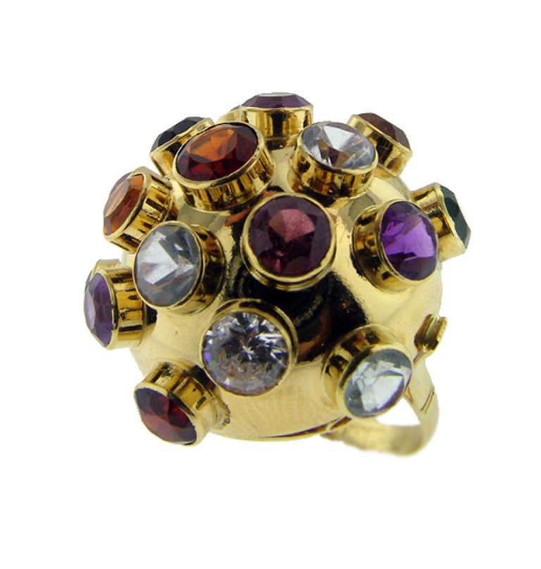 This ring is clearly marked 18 KT. The design is an H Stern Sputnik ring, however there is no H Stern signature and it may have been removed when this ring was sized. It holds numerous semi-precious stones and is in good condition. The ring measures