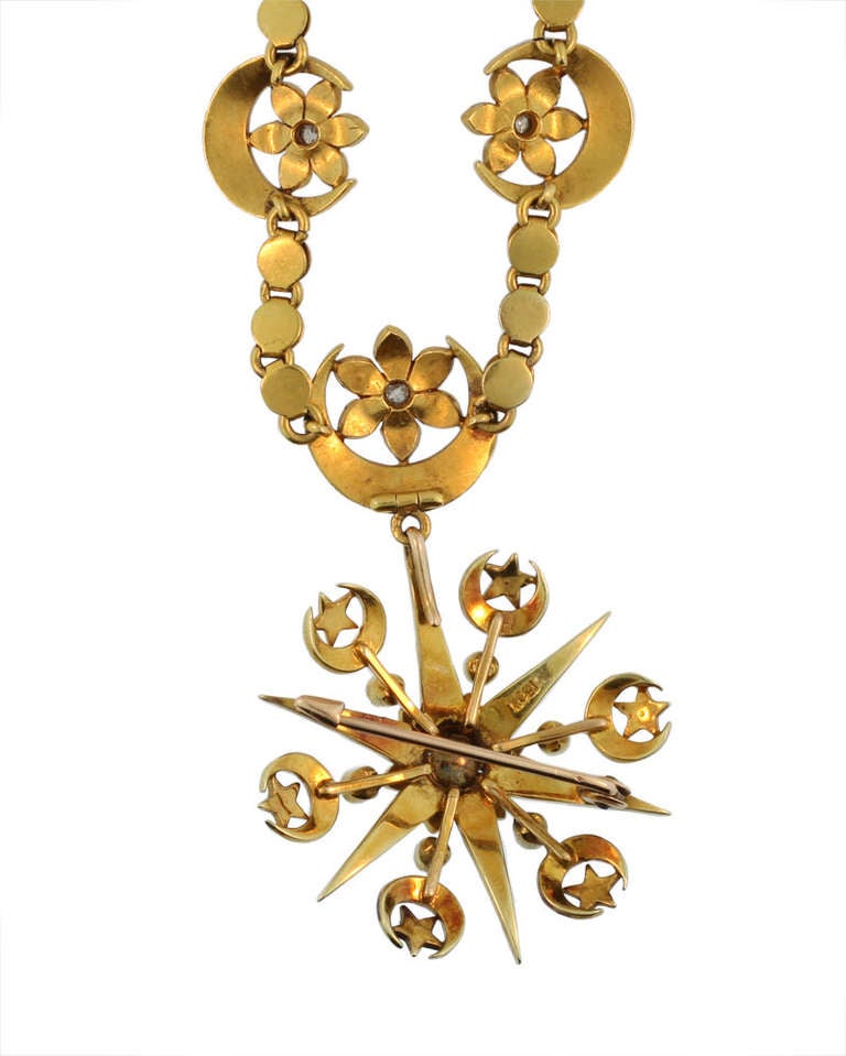 This very fine Victorian necklace is set in 15 KT yellow gold, which is stamped.  It features five crescent moons holding a tiny flower, each set with a mine cut diamond. The necklace suspends a gold and pearl star brooch which can be detached. The