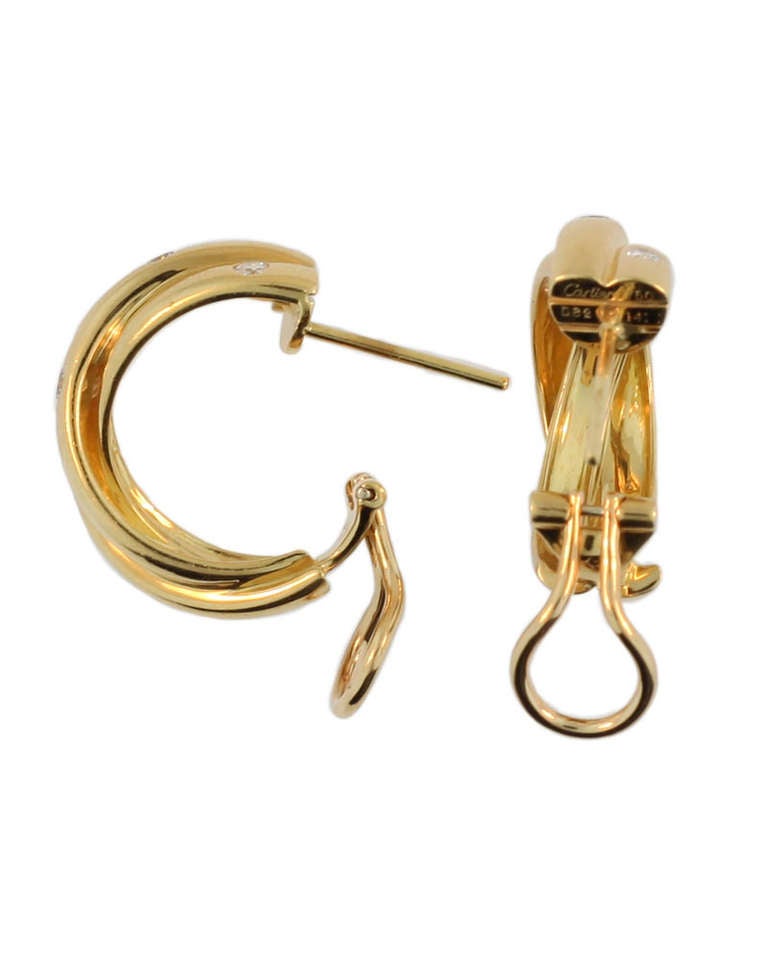 These classic Cartier Trinity earrings are 18 kt yellow gold. The diamond weight is .82, which is clearly stamped on each earring. They bear the Cartier signature mark and registration number 141 as well as 750. Additionally they are dated 1995.