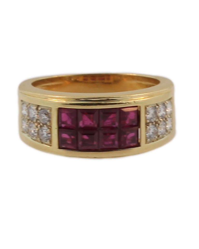 18 kt yellow gold diamond and invisibly set ruby ring, signed Cartier, registration mark 305029, 750. 12 round brilliant cut diamonds approximately .50 cts and 8 square cut rubies approximately 1 cts. This ring is in good condition, however it has