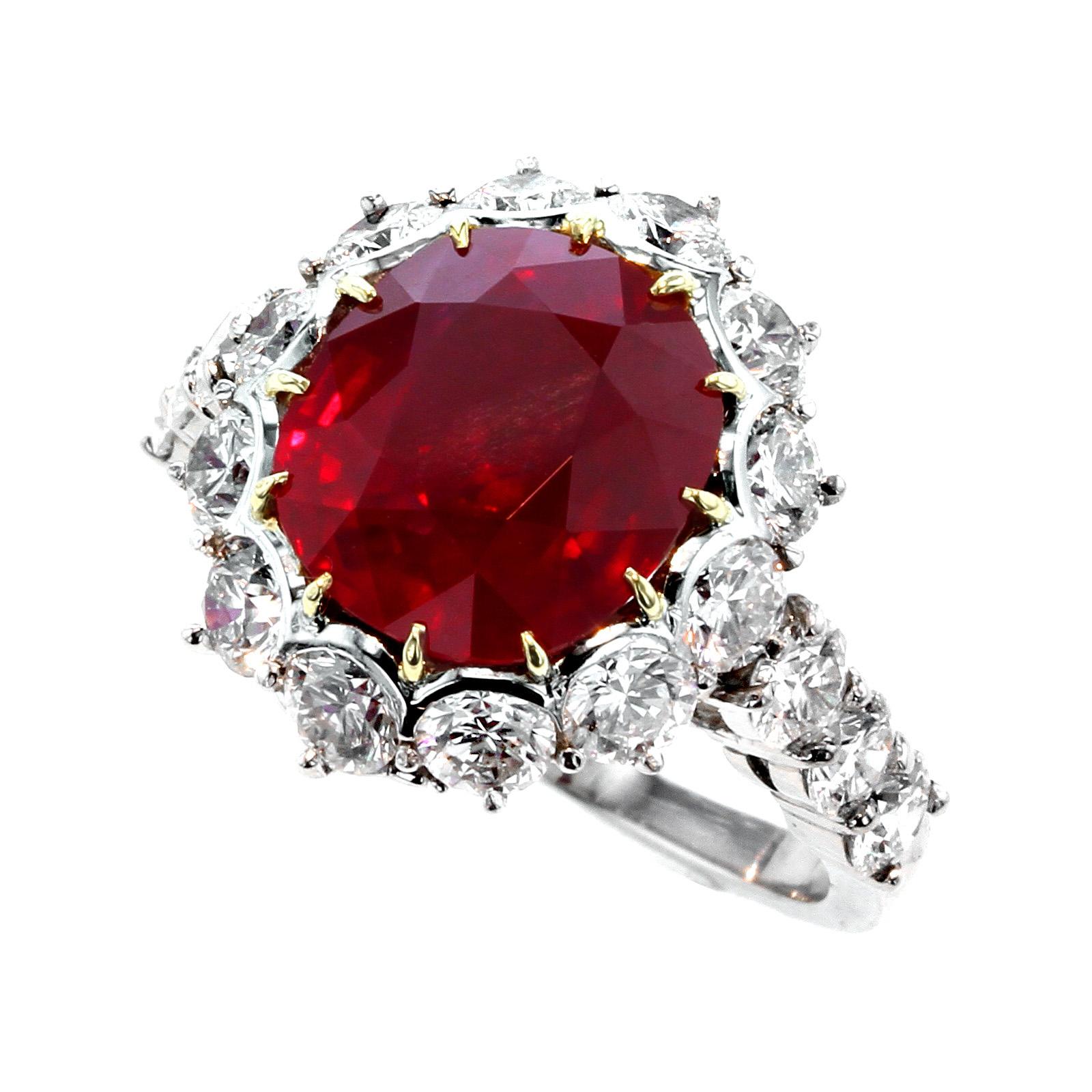 A beautiful and stunning ring centered with a five carat ruby from the coveted mines of Burma (Myanmar) surrounded with eighteen round brilliant-cut diamonds, along with a diamond encrusted 'G'; stamped GARRARD, and PT900, ring size 5 3/4 US.

The