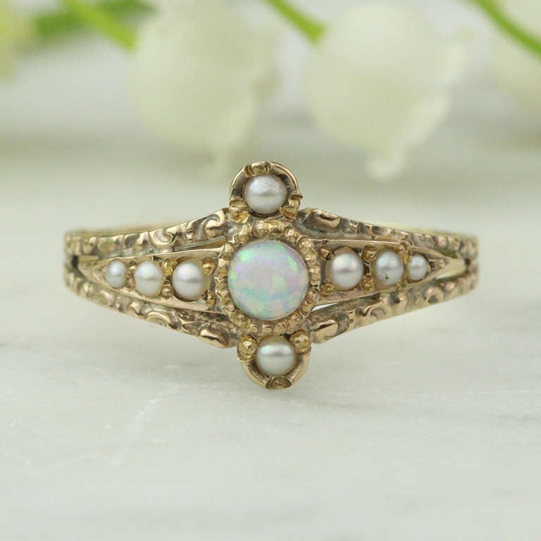 - Antique Opal and Pearl Ring
- c. 1870-1890
- 14k rose gold, seed pearls, black crystal opal

This stunning antique ring offers it all: a magnificent center opal with a translucent dark bodycolor that gives it dazzling life and play of color,