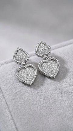 Elegantes pendientes colgantes con doble corazón y diamantes en oro blanco de 18 quilates