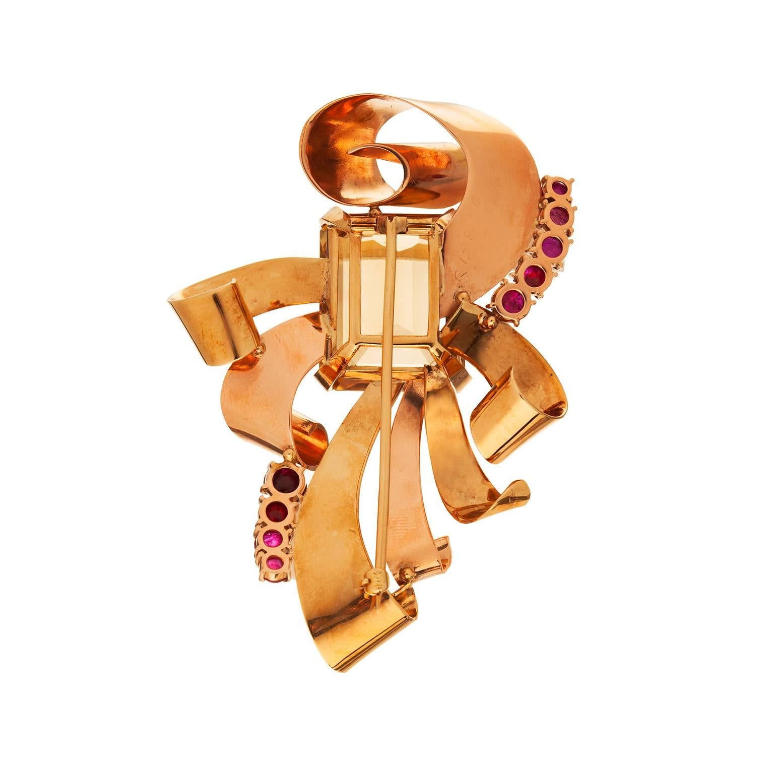 A great, large bow brooch with citrine and ruby in 14k yellow and rose gold.  The emerald cut citrine is an estimated 45.00cts, with nine cabochon cut rubies weighing and estimated 5.00cts.