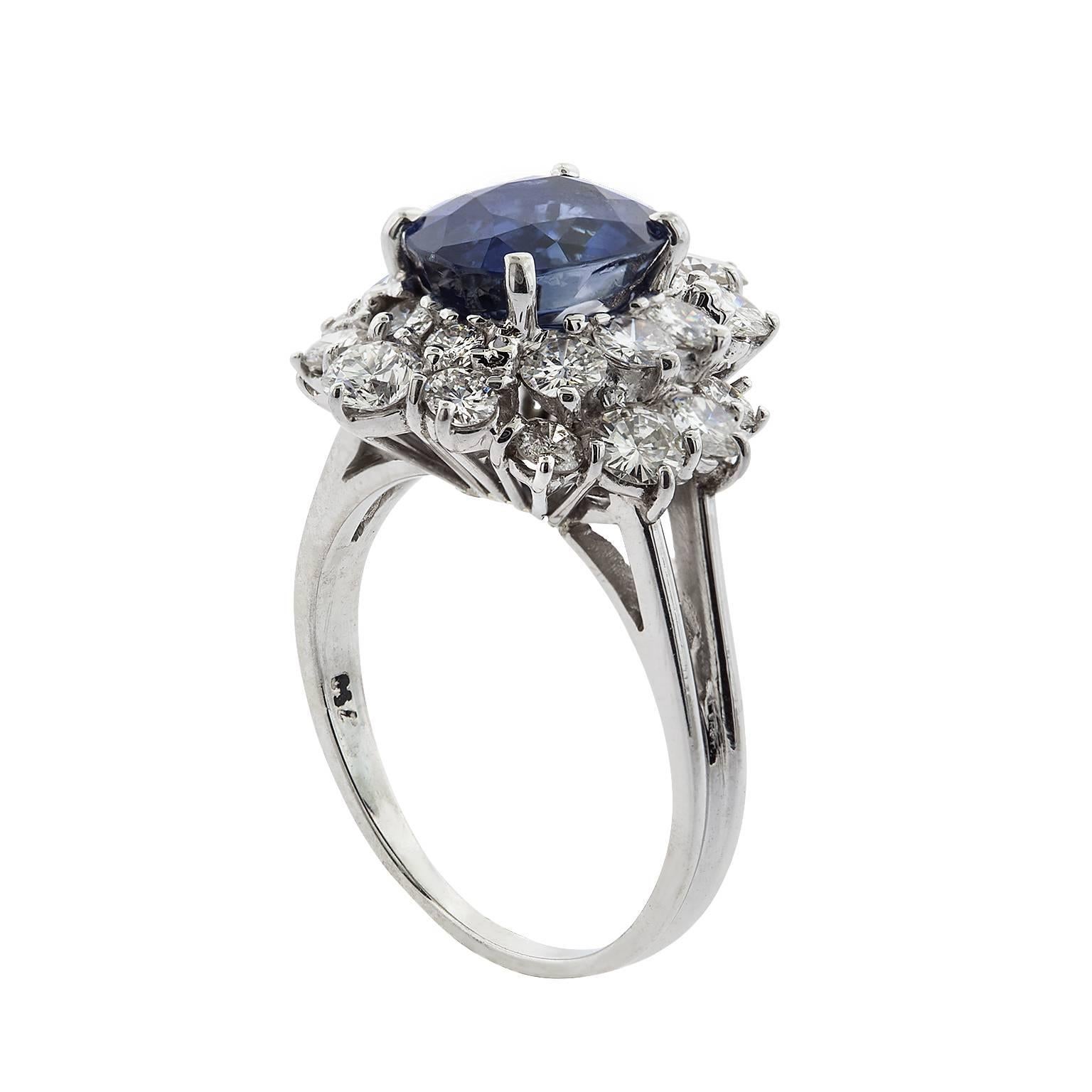 3.12 carat oval sapphire and diamond ring in 18 karat white gold.  The sapphire is set with four prongs, and surrounded by two rows of staggered height round brilliant diamonds.  The diamonds have a total weight of 1.85 carats, and are G/H color,