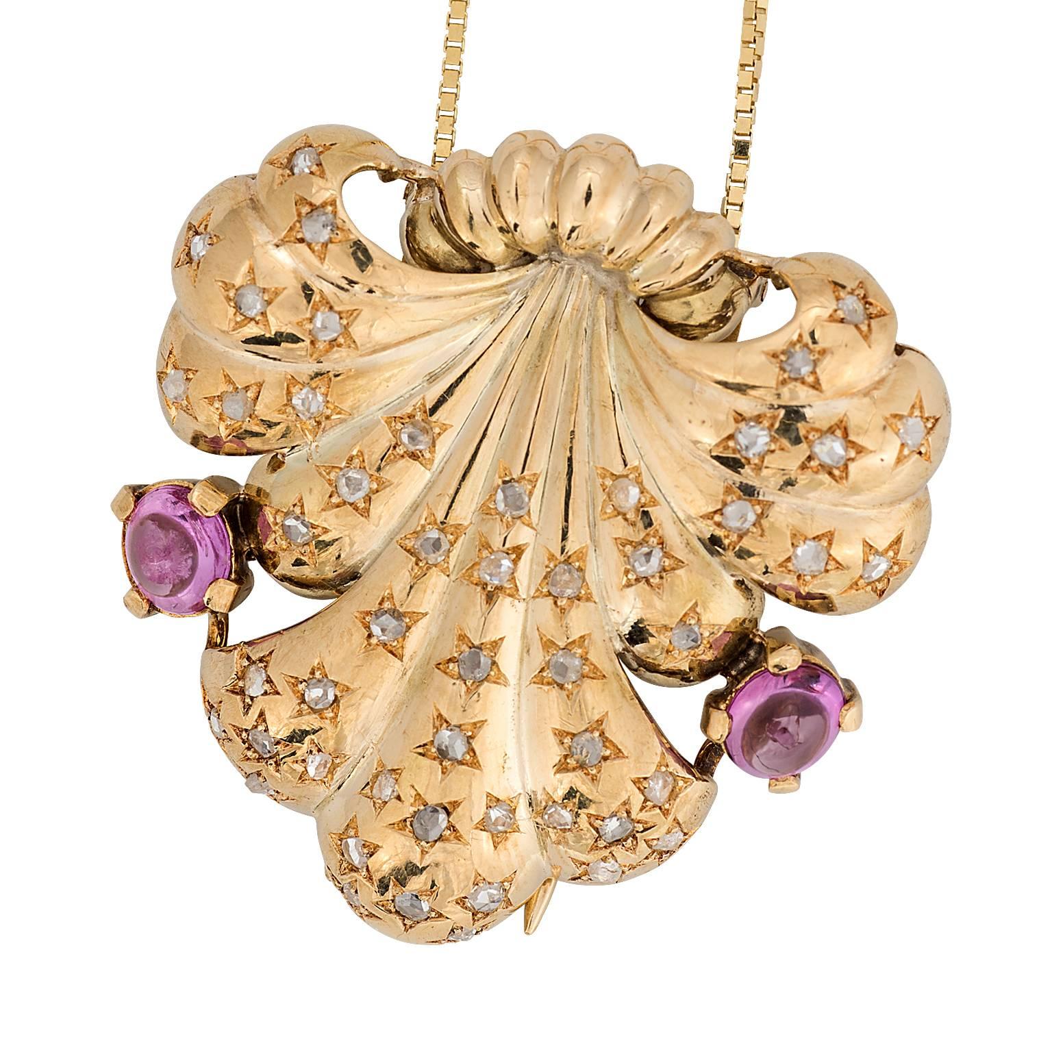 An Art Deco diamond and pink sapphire 18 karat yellow gold clip.  Designed as a spray with old rose cut diamonds set in star shaped openings throughout, and two cabochon pink sapphires towards the top.  The diamonds have a total weight of 0.50