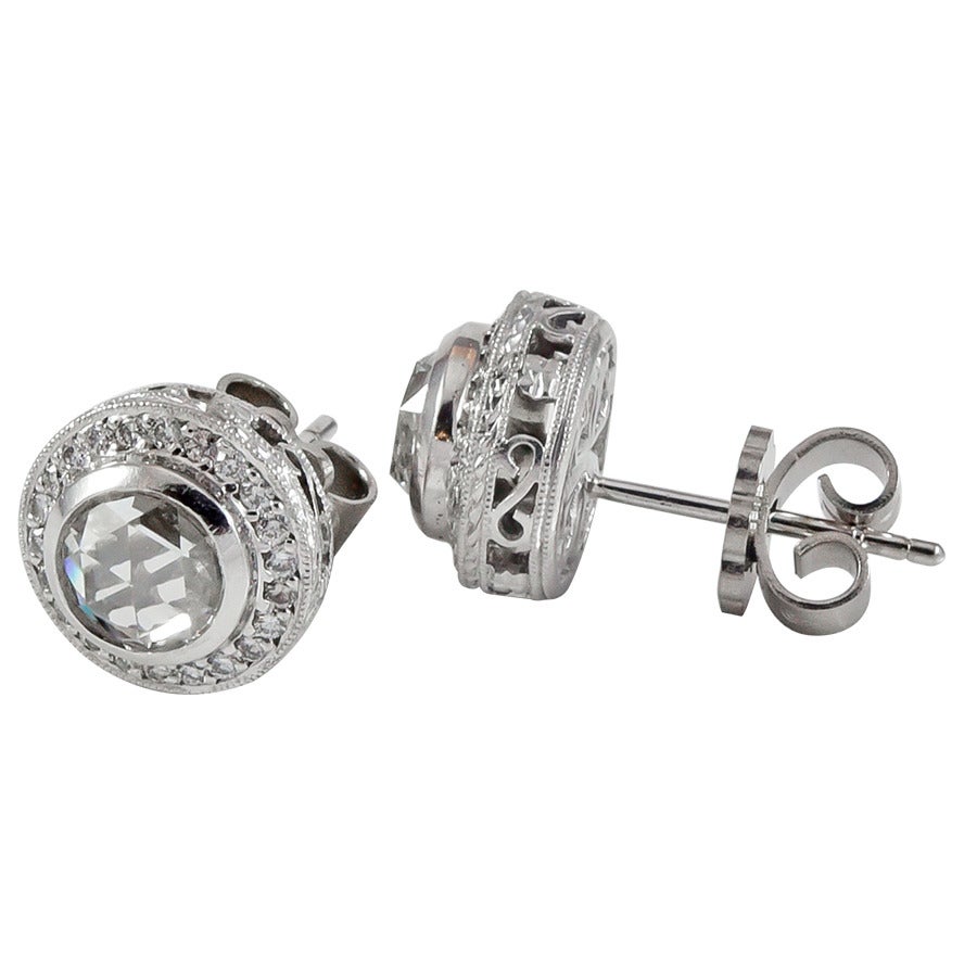 Beautiful rose cut diamond stud earrings in platinum.  The center bezel set diamonds have a total weight of 2.00cts, surrounded by a single row of round brilliant cut diamonds, with a total weight of .50cts.  The diamonds are G-H color,