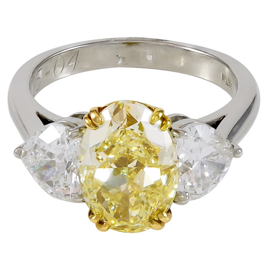 An absolutely stunning diamond ring!  The center diamond is 4.36cts, fancy light yellow, VS2 clarity, as graded by GIA.  The two side diamonds are heart brilliant shapes, one is a 1.01ct, D color, Si1 clarity, as graded by GIA.  The other diamond