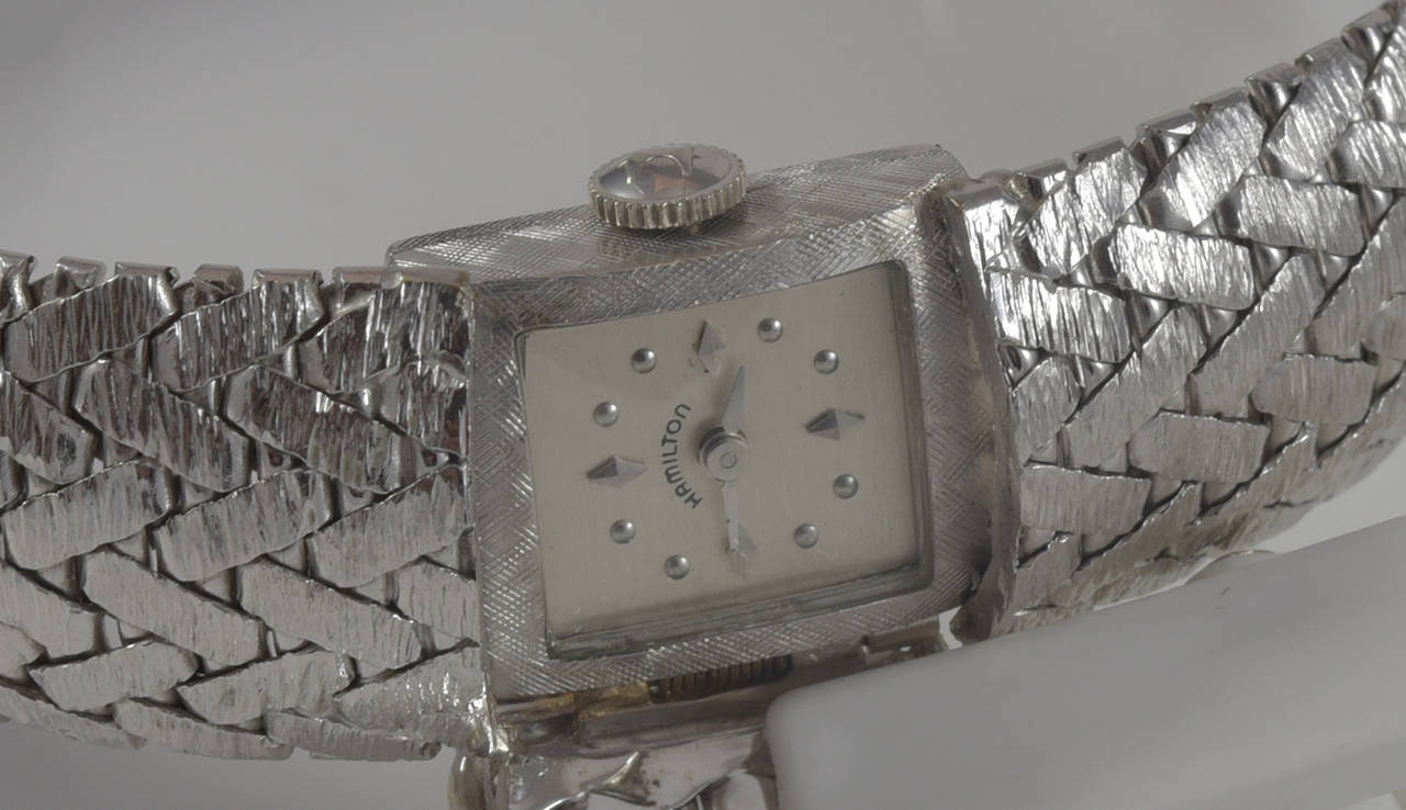 A beautiful ladies Hamilton watch.  The watch features a hidden dial, in all 14k white gold with two rows of diamonds.  The cover is on a hinge that flips open to view the dial.  There is an estimated 0.25cts in diamond.  The watch is a manual wind