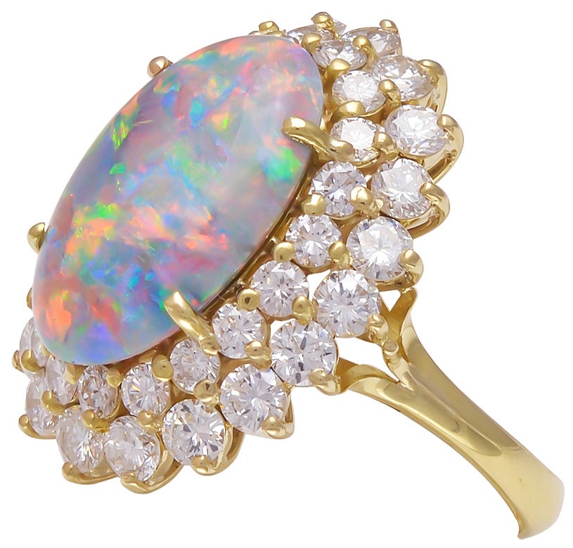 This opal ring displays beautiful play of color!  The cabochon cut opal is 5.14cts.  It has an American Gemological Laboratories report stating that it is natural, origin of Australia, and dominant colors of red, orange, green, and blue.  The opal