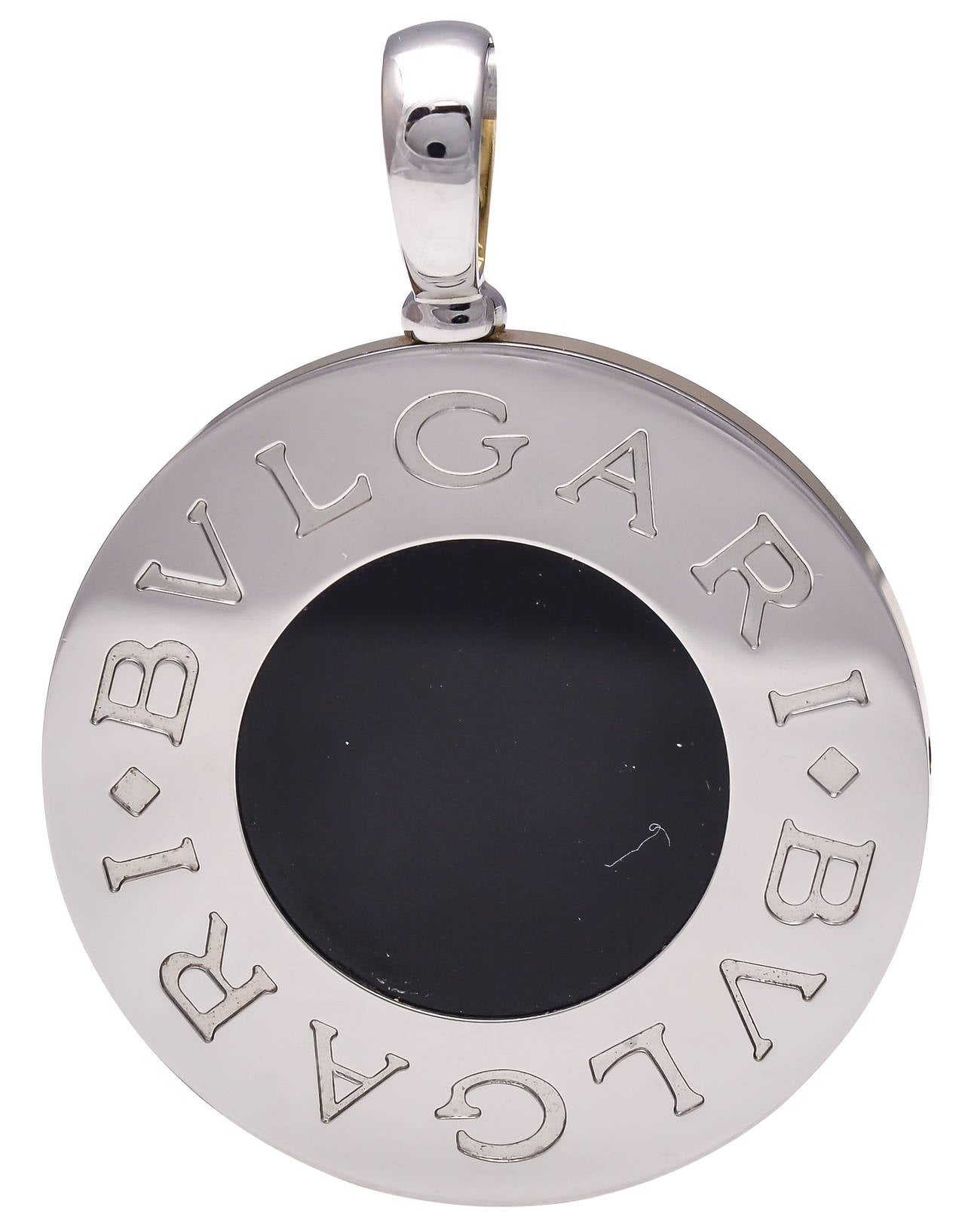 A beautiful reversible pendant by Bulgari.  The one side of the pendant displays mother of pearl with 18kt yellow gold framing, while the opposite side displays black onyx with a steel frame.

Signed: Bvlgari
Numbered: 2337A
Stamped: 750   Steel