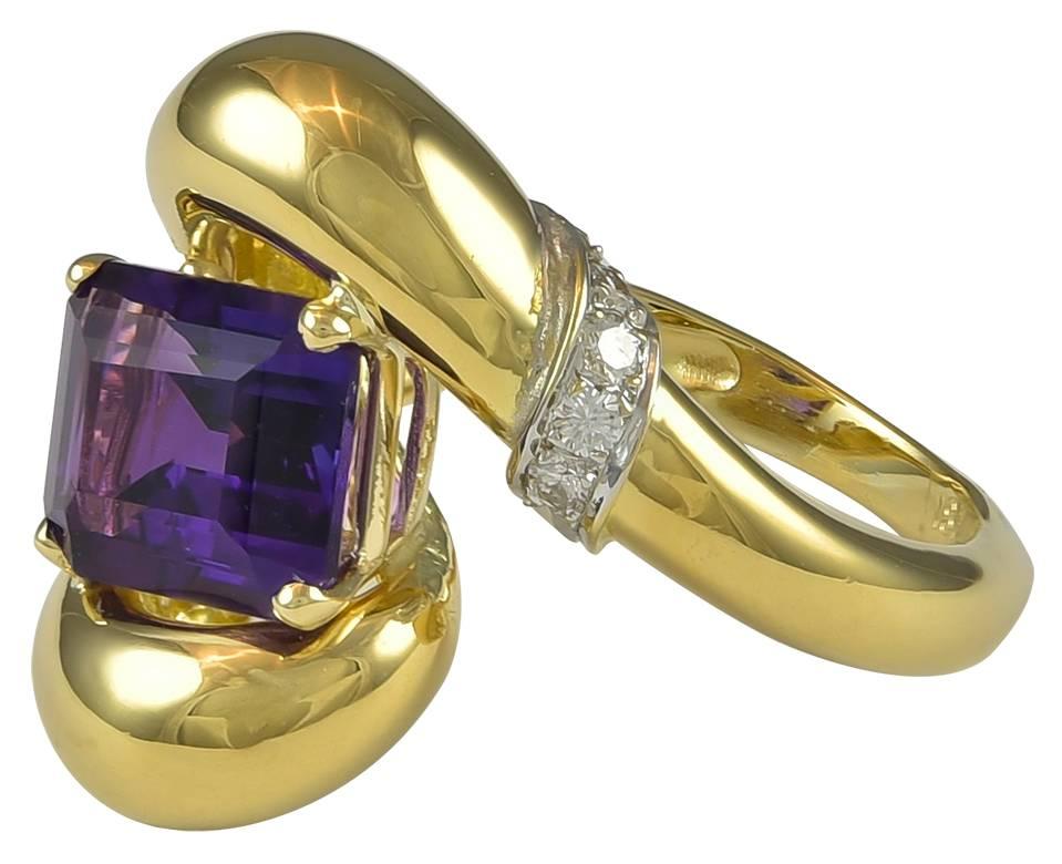 A great fashion ring made up of amethyst diamond and 18K yellow gold designed as a retro style twist.  The emrald cut amethyst is 2.49cts, set in a four prong basket, with two channel diamond stations on the shank containing .16cts total. 