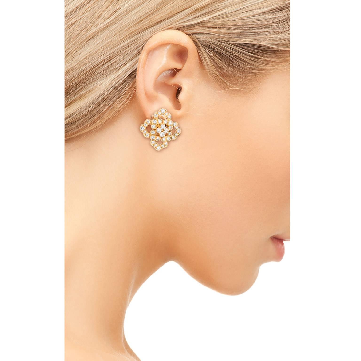 A beautiful pair of Van Cleef & Arpels Diamond and 18K yellow gold clip and post earrings.  Designed in three tiers, with the center being a cluster of four diamonds.  The diamonds are all round brilliant cuts, weighing an estimated 4.12cts total,