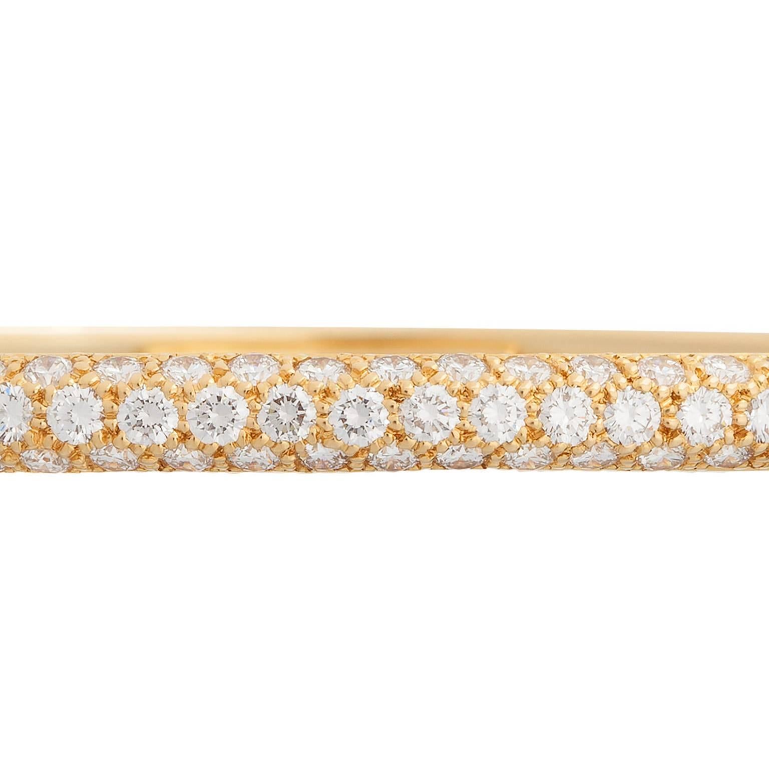 A wonderful Tiffany & Co. pave diamond bangle bracelet.  The diamonds are all round brilliant cuts, set into three rows, in 18K yellow gold, weighing an estimated 2.50cts total.  The diamonds go halfway around the bracelet, and the bracelet has a