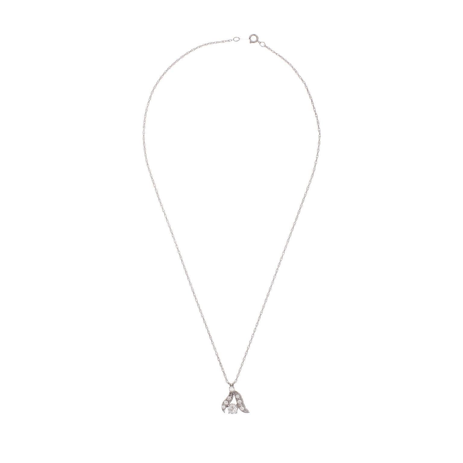 A beautiful, easy to wear diamond pendant necklace.  The round brilliant diamonds are set in 14k white gold, in the form of a budding tree branch.  The center diamond is estimated to be .60cts, G-H color, VS2 clarity, with seven smaller diamonds