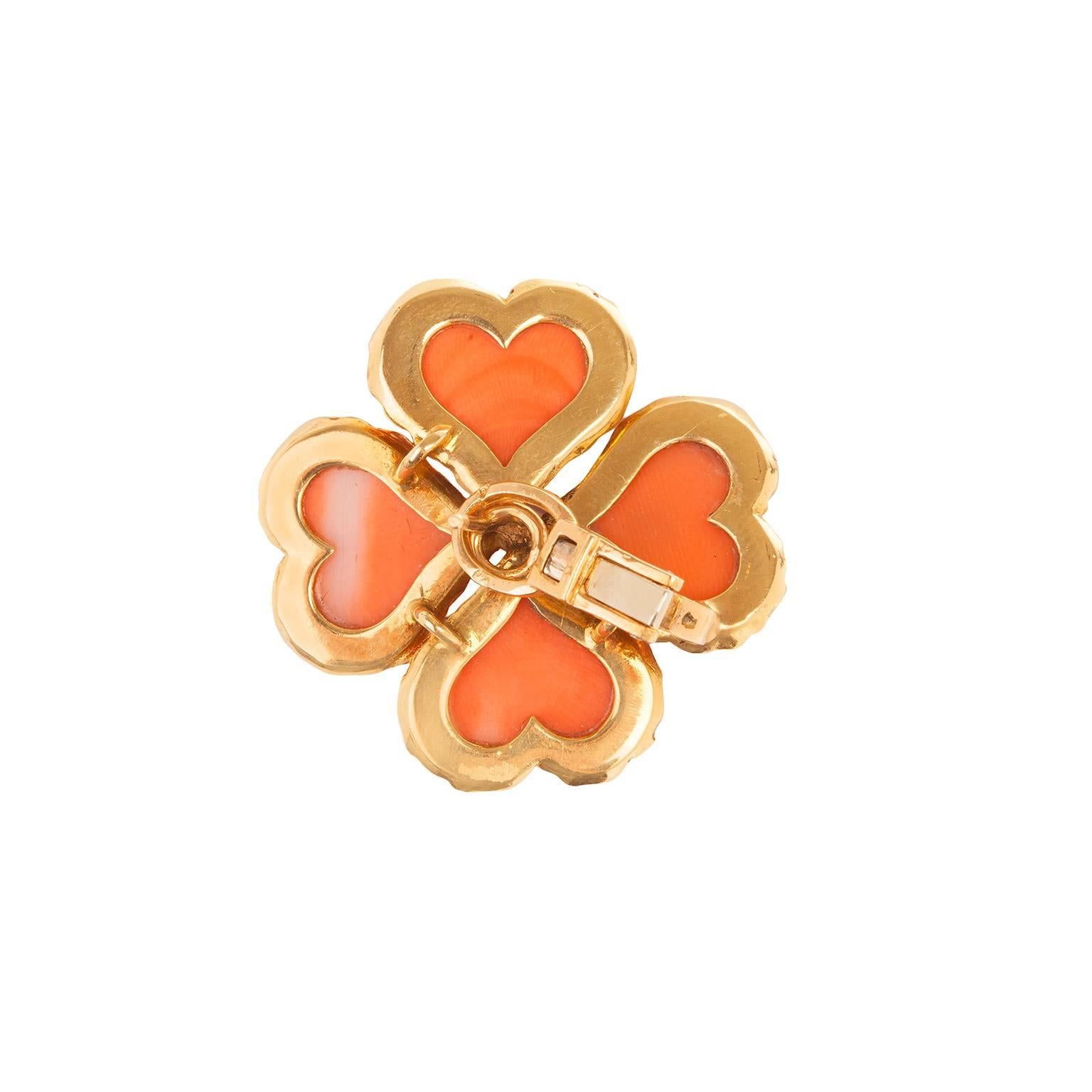 A with a single prong set dimo wonderful pair of coral and diamond earrings set in 18k yellow gold.  The earrings are designed in the shape of a clover with a single prong set diamond in the center of each  with a total weight of