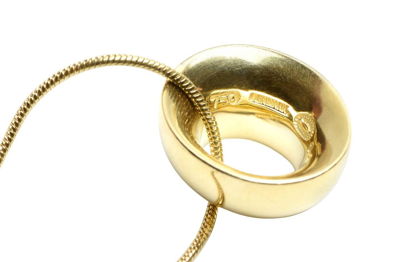 A very simple yet elegant piece made by famous designer Georg Jensen. The pendant is an oval shaped curved edge disc suspended from a snake chain in 18k yellow gold.

Signature: Georg Jensen
Hallmark: 750 Denmark
Measurement: 18.00 inches