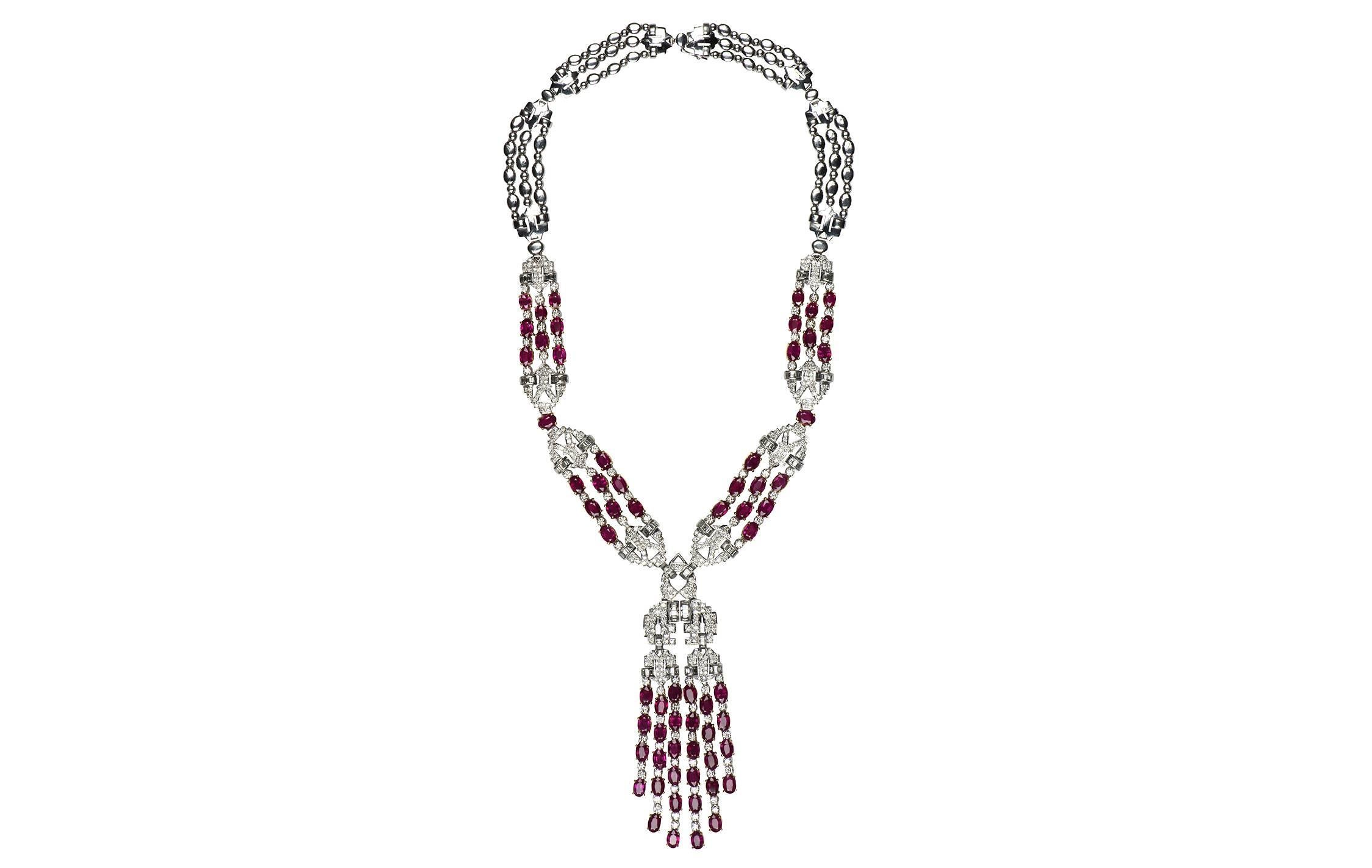 A stunning ruby and diamond 18k white gold lariat necklace.  The necklace contains 64 oval rubies totaling an estimated weight of 30.98cts, with a combination of 414 round brilliant and baguette shape diamonds totaling an estimated weight of