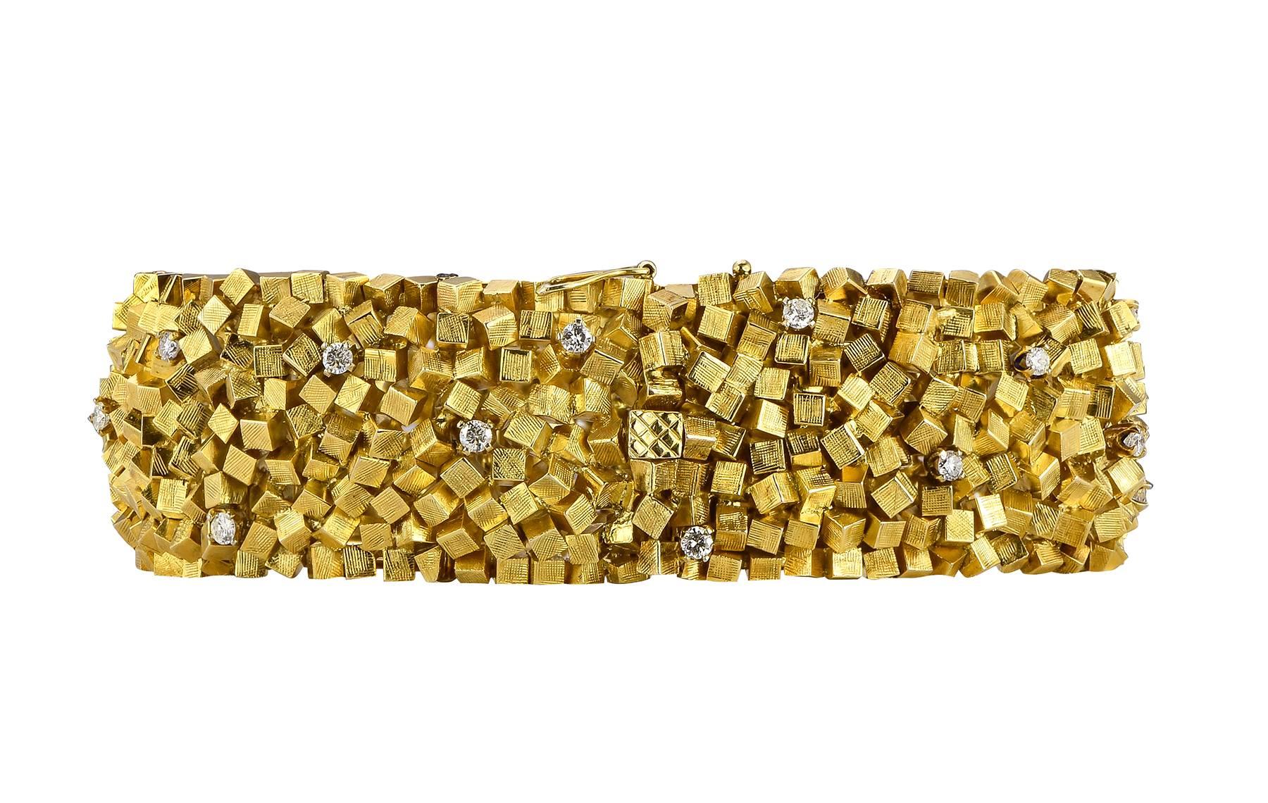 14kt. yellow gold stacked cubist style bracelet measuring 8.00 inches in length and just over a 3/4 inches in width weighing 114.16 gr. The flexible link bracelet is sprinkled with 24 prong set round brilliant diamonds totaling 0.75cts.  Circa